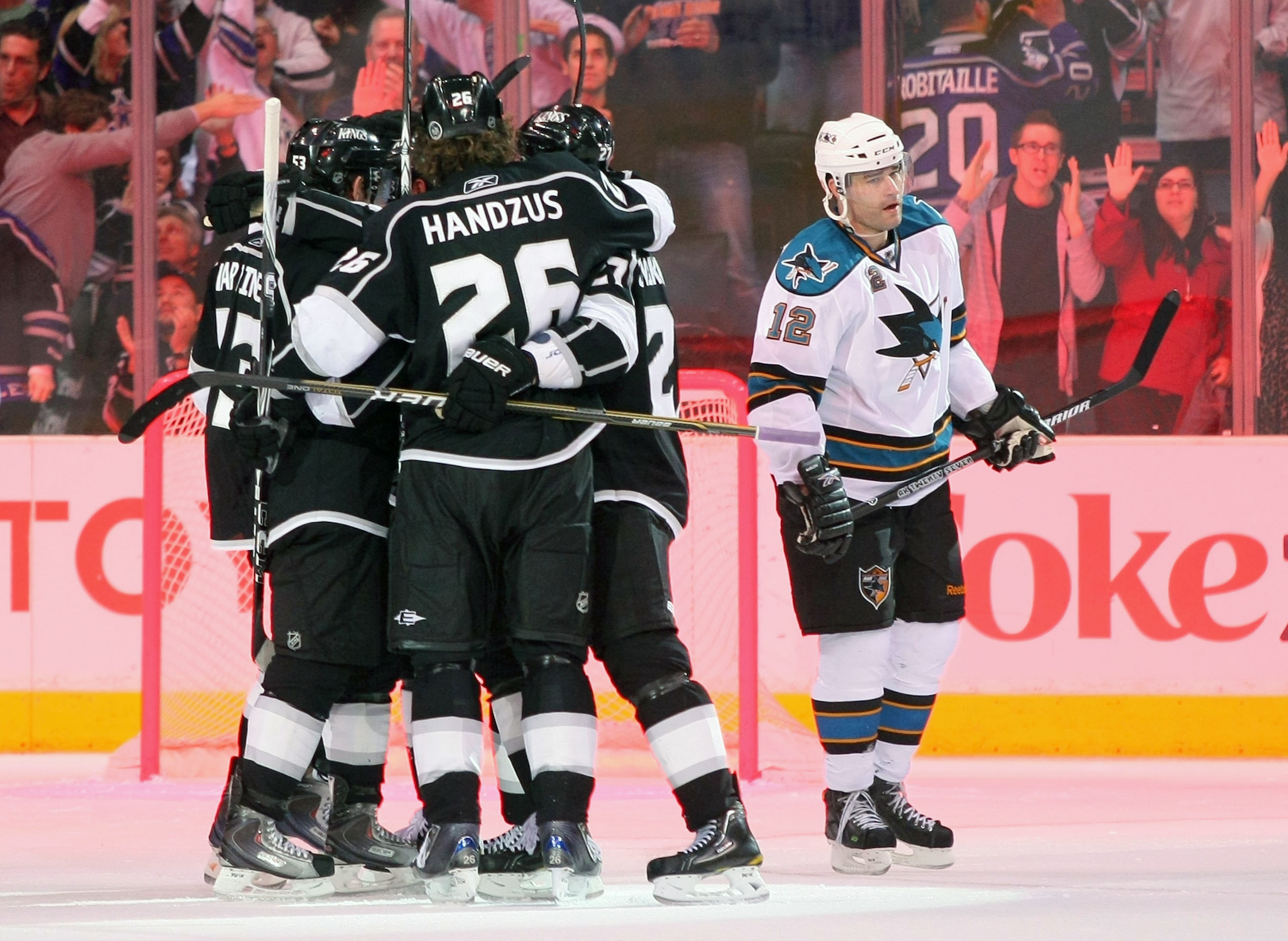 LOS ANGELES, CA - MARCH 24:  Alec Martinez #53, Michal Handzus #26, Dustin Brown #23 and Alexei Ponikarovsky #27 of the Los Angeles Kings celebrate Brown's goal in the third period as Patrick Marleau #12 of the San Jose Sharks skates to the bench during t