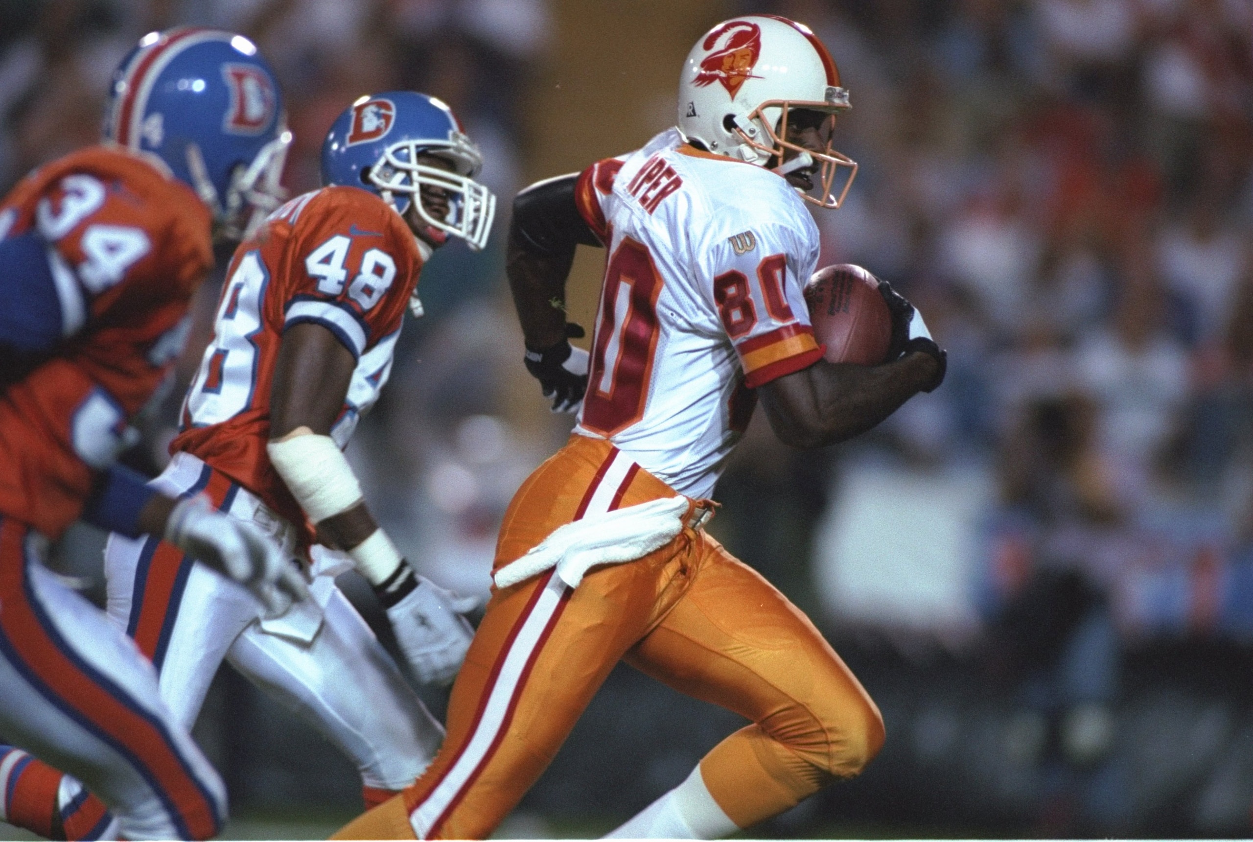 15 Sep 1996: Wide receiver Alvin Harper #80 of the Tampa Bay Buccaneers looks up field as he runs with the football while being pursued by defensive backs Lionel Washington #48 and Tyrone Braxton #34 of the Denver Broncos following a down field reception 15 Sep 1996: Wide receiver Alvin Harper #80 of the Tampa Bay Buccaneers looks up field as he runs with the football while being pursued by defensive backs Lionel Washington #48 and Tyrone Braxton #34 of the Denver Broncos following a down field reception