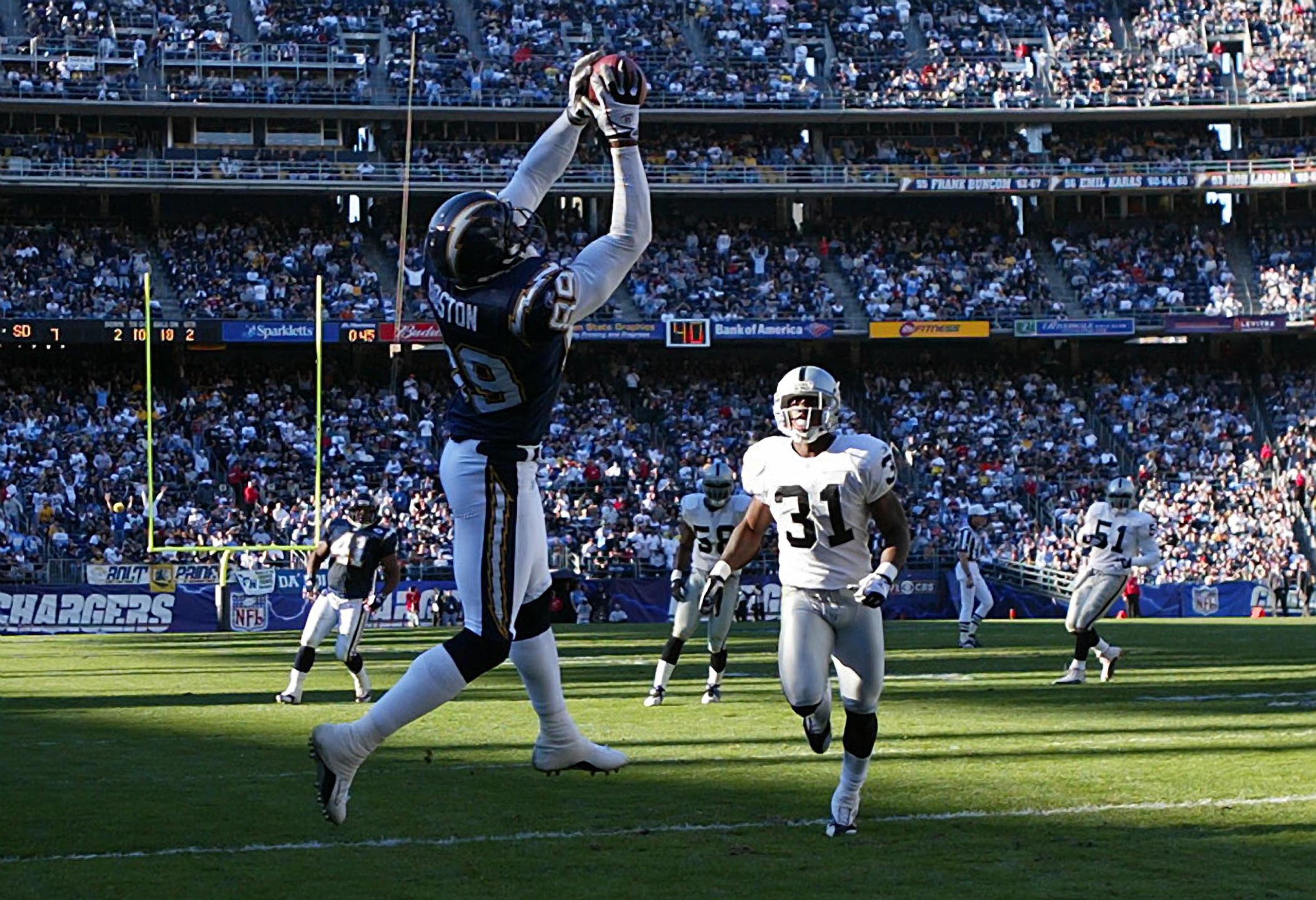 SAN DIEGO - DECEMBER 28: Wide Reciever David Boston #89 of the San Diego Chargers hauls in a touchdown pass as Phillip Buchanon #31 of the Oakland Raiders looks on in the 1st half during their NFL game on December 28, 2003 at Qualcomm Stadium in San Die SAN DIEGO - DECEMBER 28: Wide Reciever David Boston #89 of the San Diego Chargers hauls in a touchdown pass as Phillip Buchanon #31 of the Oakland Raiders looks on in the 1st half during their NFL game on December 28, 2003 at Qualcomm Stadium in San Die