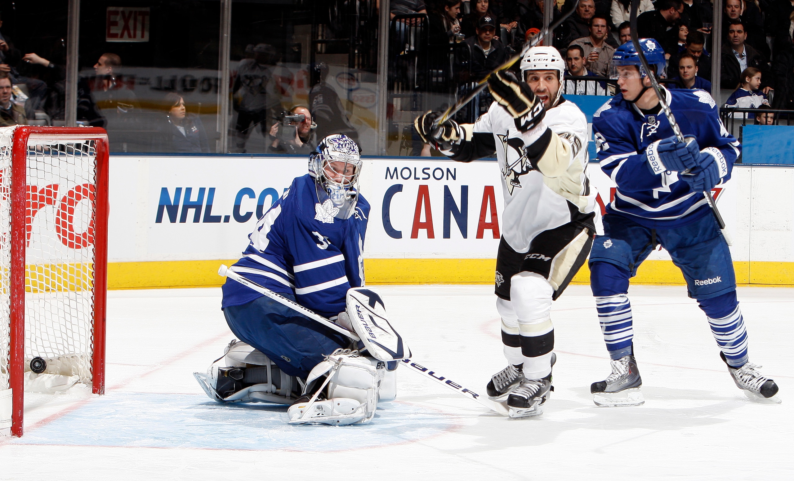 TORONTO, CANADA - MARCH 2: James Reimer #34 and Tyler Bozak #42 of the Toronto Maple Leafs watch as the puck goes in with Maxime Talbot #25 of the Pittsburgh Penguins celebrating the goal of teammate Matt Niskanen #2 during game action at the Air Canada C