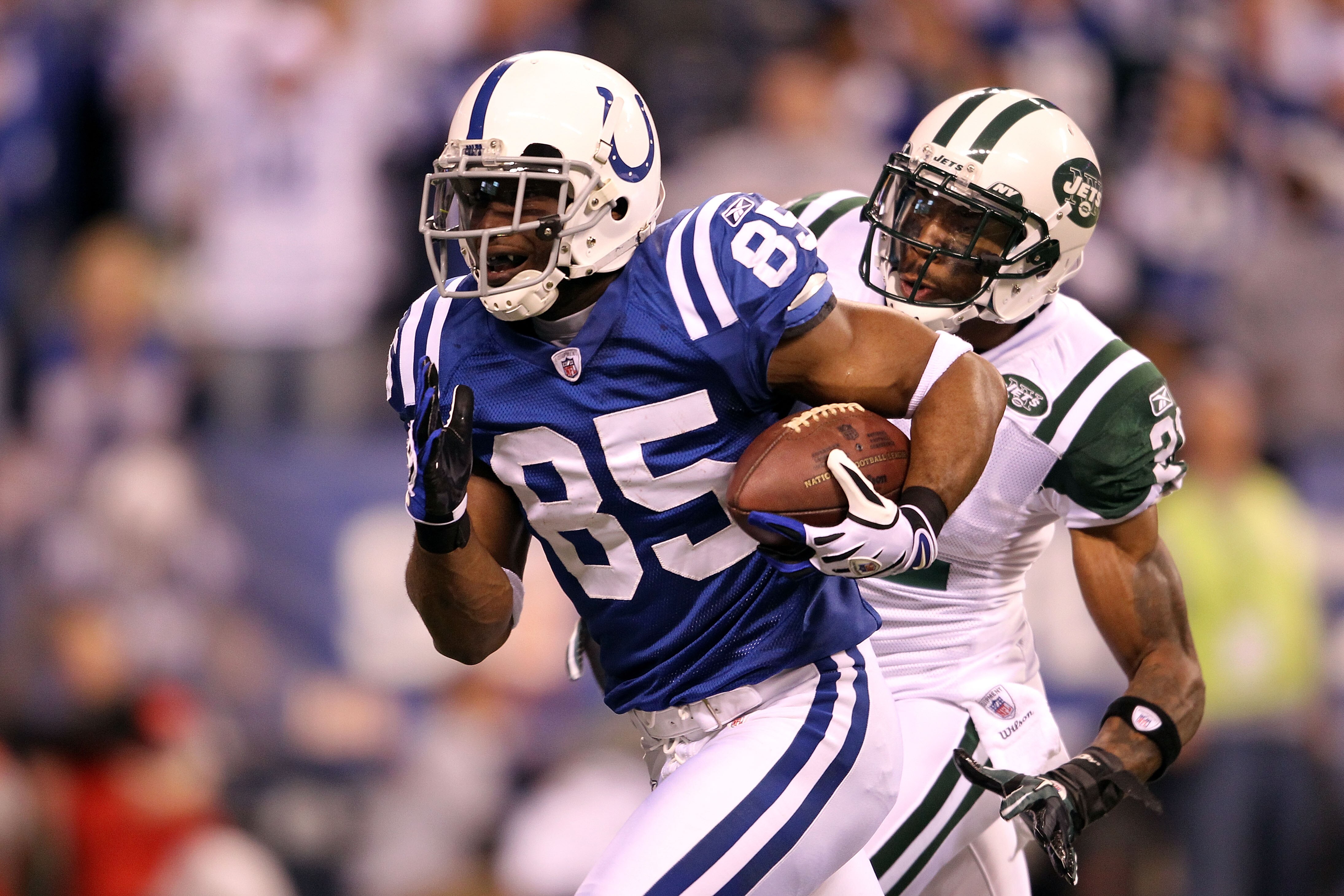 INDIANAPOLIS, IN - JANUARY 08:  Pierre Garcon #85 of the Indianapolis Colts scores on a 57-yard touchdown reception in the seocnd quarter against Antonio Cromartie #31 of the New York Jets during their 2011 AFC wild card playoff game at Lucas Oil Stadium