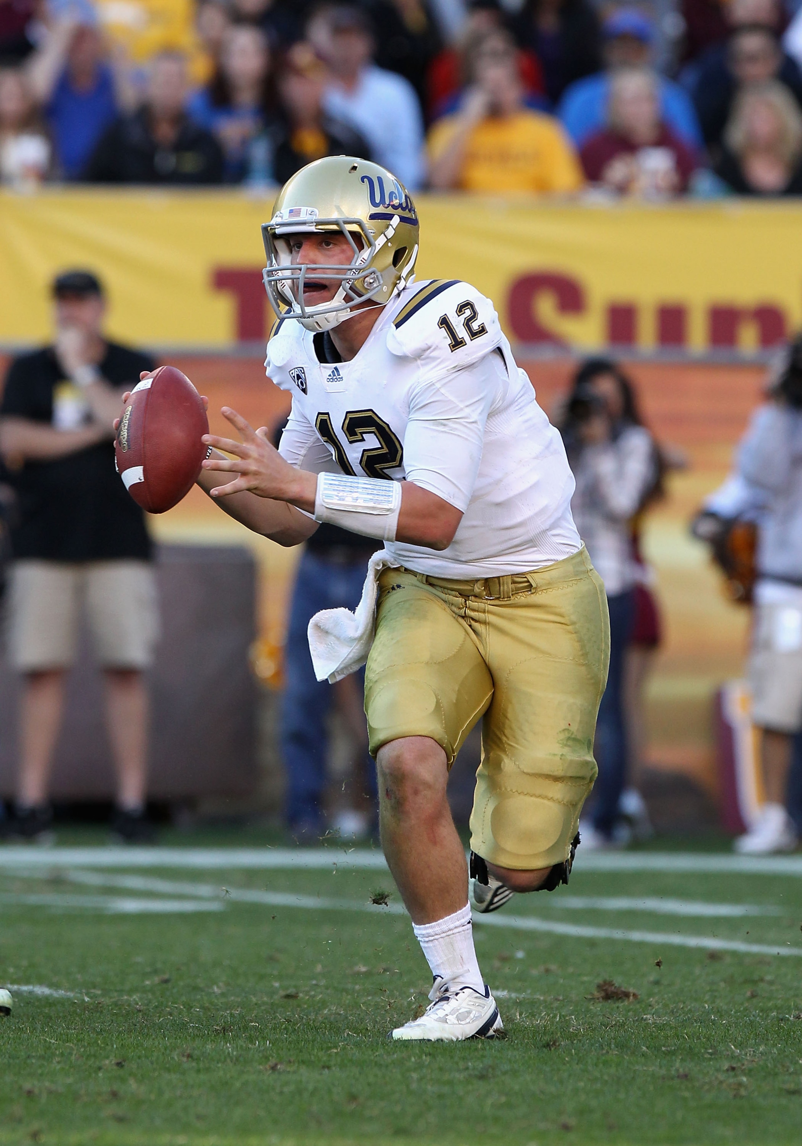 TEMPE, AZ - NOVEMBER 26:  Quarterback Richard Brehaut #12 of the UCLA Bruins scrambles with the ball during the college football game against the Arizona State Sun Devils at Sun Devil Stadium on November 26, 2010 in Tempe, Arizona. The Sun Devils defeated