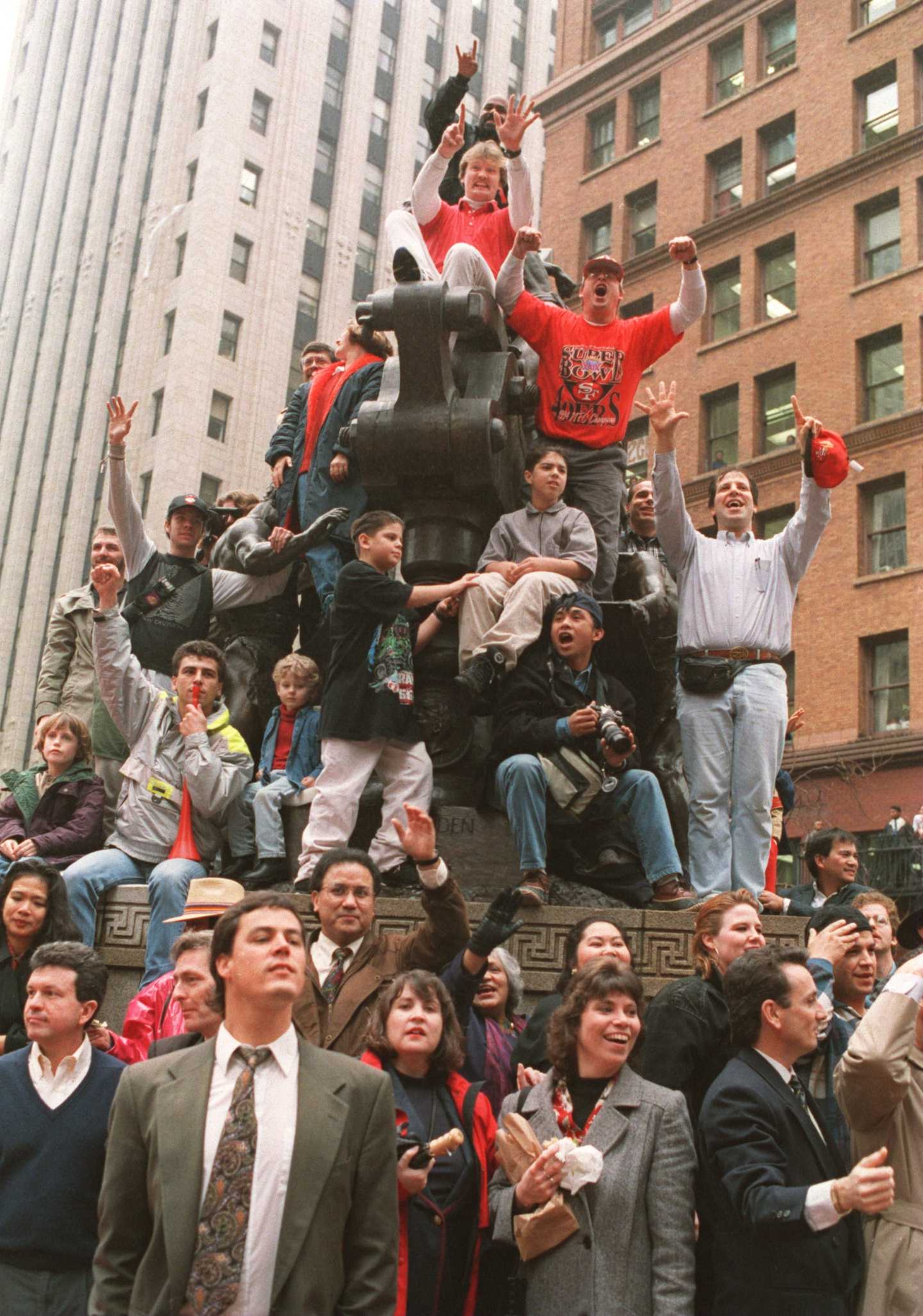 30 JAN 1995: FANS GATHER ON AND AROUND A STATUE TO CHEER ON THE 49ERS DURING A PARADE ON MARKET STREET IN DOWNTOWN SAN FRANCISCO, CALIFORNIA. THOUSANDS WELCOMED HOME THE 49ERS AFTER THEY DEFEATED THE SAN DIEGO CHARGERS, 49-26 YESTERDAY IN MIAMI,FLORIDA. 30 JAN 1995: FANS GATHER ON AND AROUND A STATUE TO CHEER ON THE 49ERS DURING A PARADE ON MARKET STREET IN DOWNTOWN SAN FRANCISCO, CALIFORNIA. THOUSANDS WELCOMED HOME THE 49ERS AFTER THEY DEFEATED THE SAN DIEGO CHARGERS, 49-26 YESTERDAY IN MIAMI,FLORIDA.