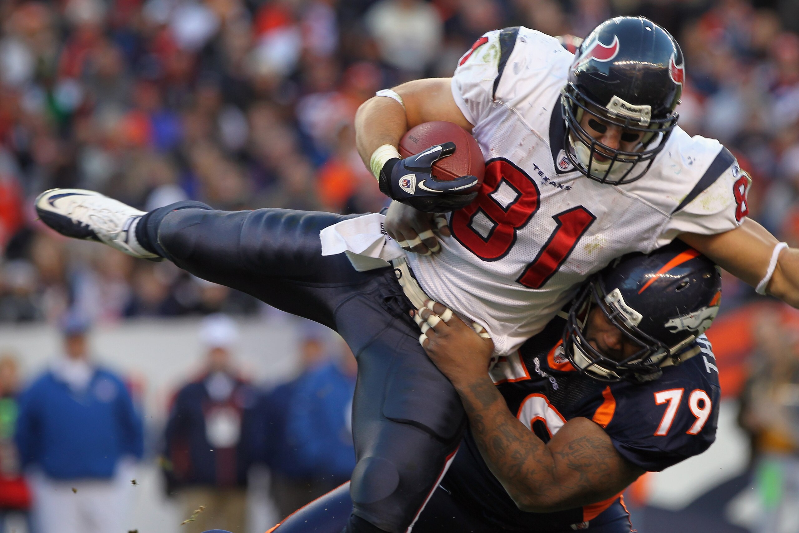DENVER - DECEMBER 26:  Wide receiver Owen Daniels #81 of the Houston Texas makes a reception and is tackled by defensive lineman Marcus Thomas #79 of the Denver Broncos at INVESCO Field at Mile High on December 26, 2010 in Denver, Colorado. The Broncos de