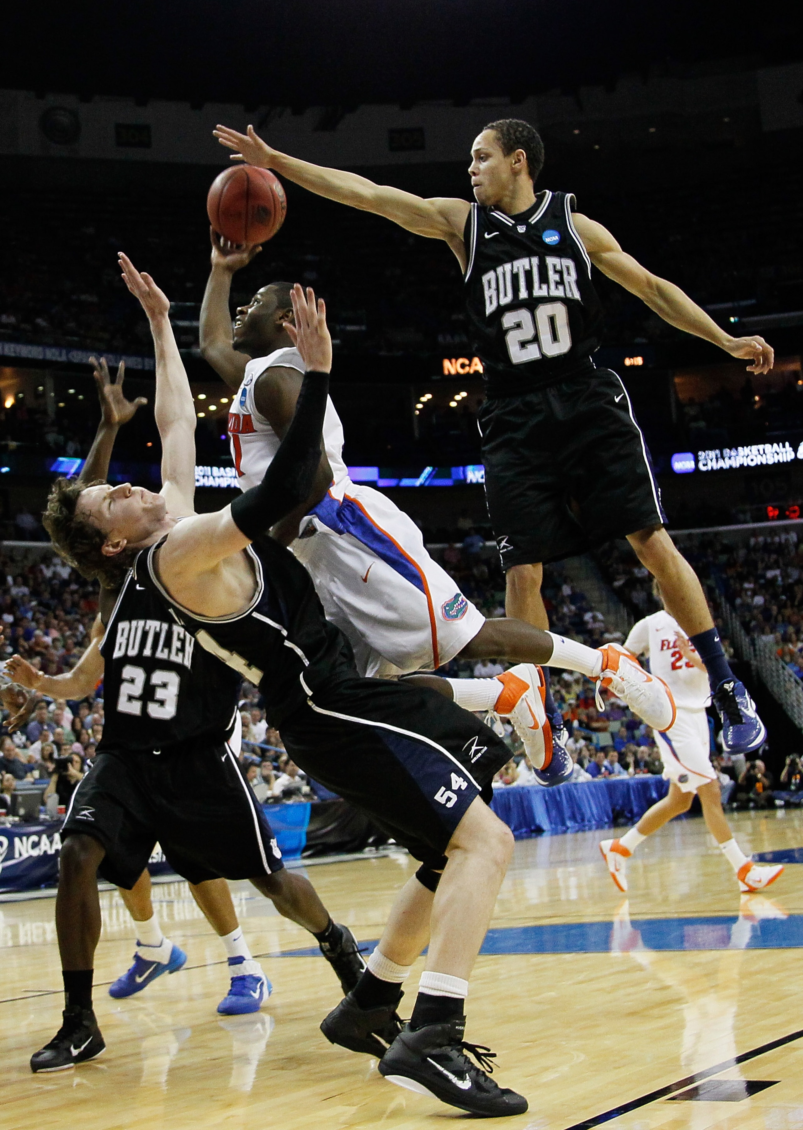 NEW ORLEANS, LA - MARCH 26:  Erving Walker #11 of the Florida Gators fouls Matt Howard #54 as Chrishawn Hopkins #20 of the Butler Bulldogs tries to block his shot in the second half during the Southeast regional final of the 2011 NCAA men's basketball tou