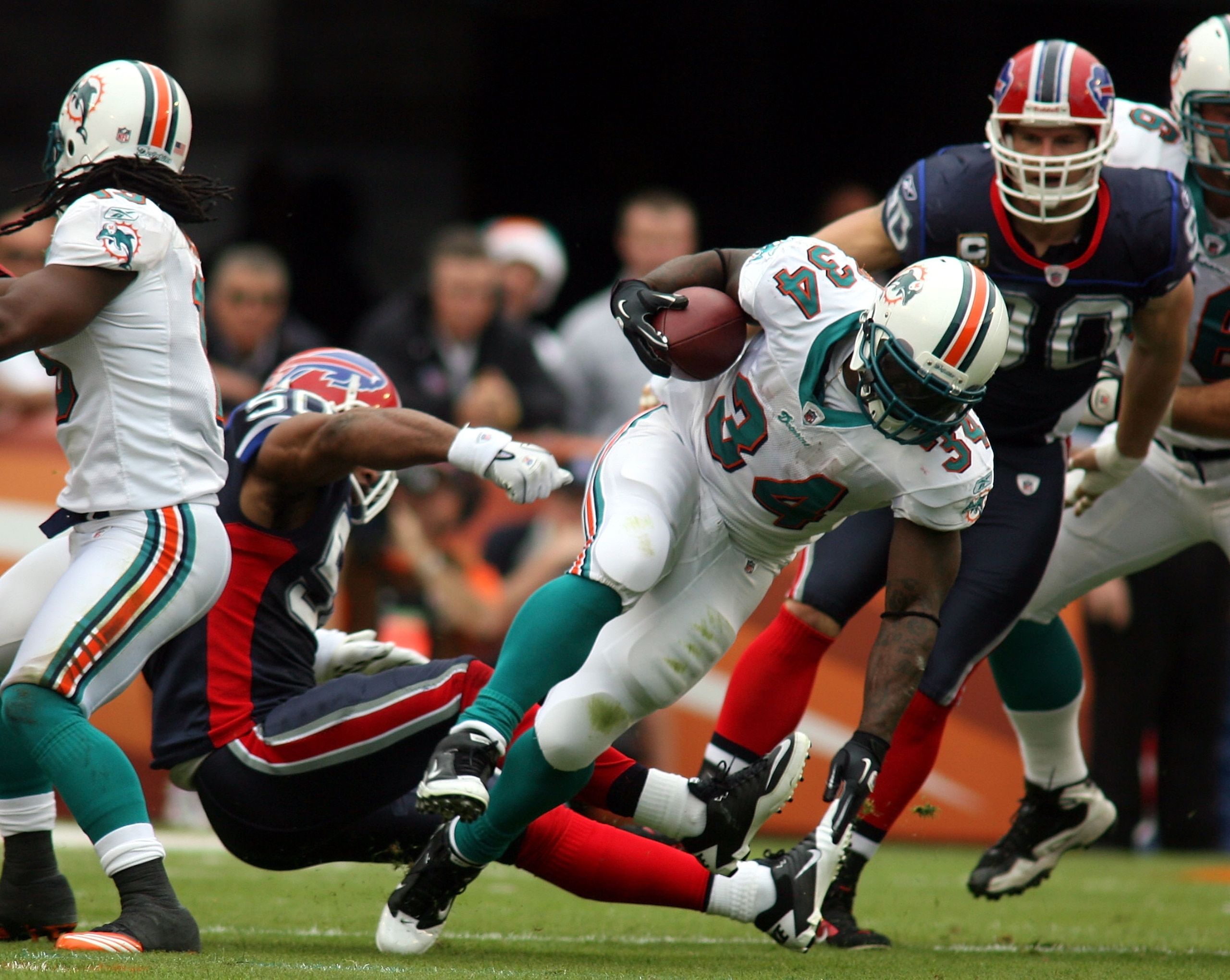 MIAMI, FL - DECEMBER 19: Running back Ricky Williams #34 of the Miami Dolphins is upended by cornerback Donte Whitner #20 of the Buffalo Bills during a game at Sun Life Stadium on December 19, 2010 in Miami, Florida. The Bills defeated the Dolphins 17-14 MIAMI, FL - DECEMBER 19: Running back Ricky Williams #34 of the Miami Dolphins is upended by cornerback Donte Whitner #20 of the Buffalo Bills during a game at Sun Life Stadium on December 19, 2010 in Miami, Florida. The Bills defeated the Dolphins 17-14