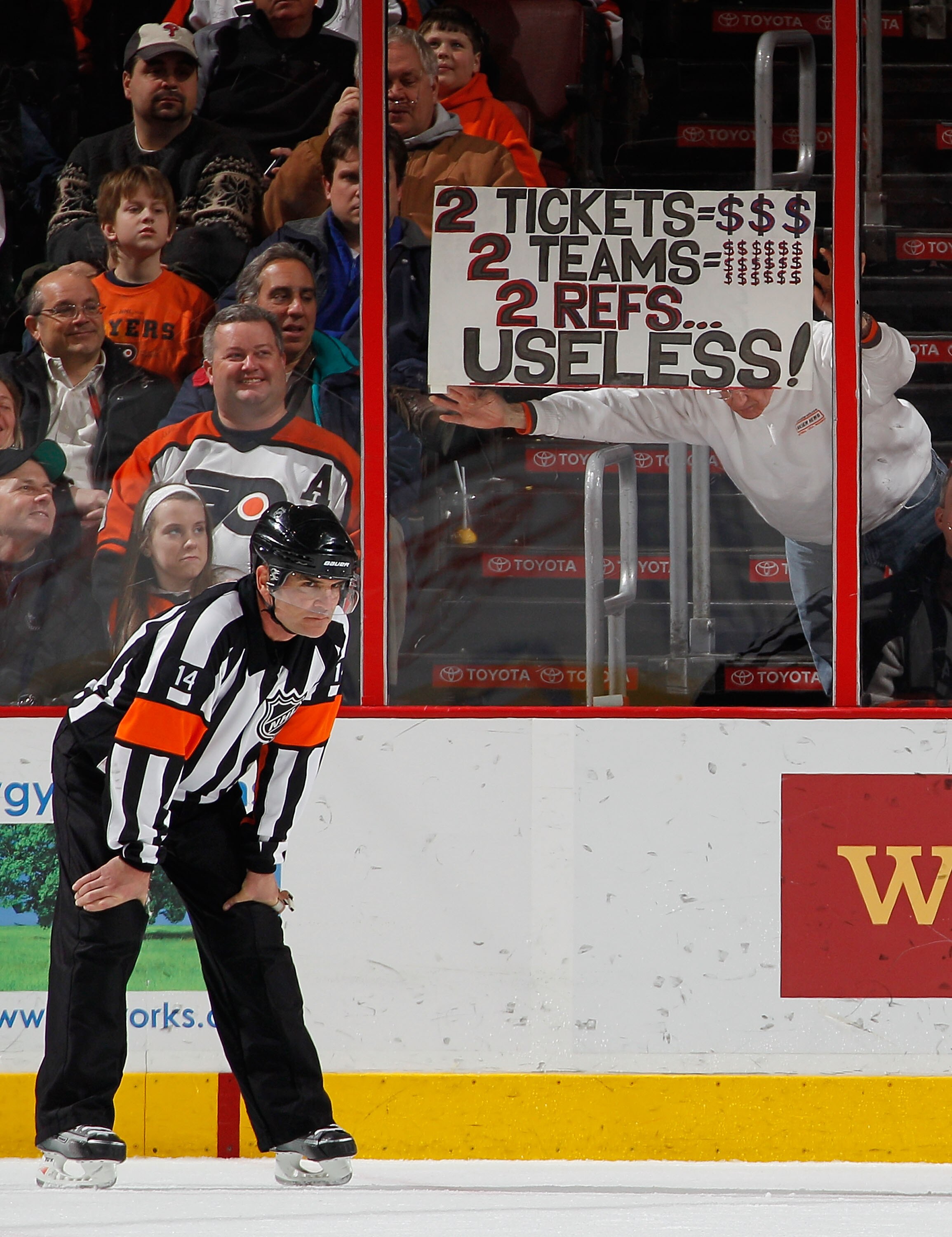 PHILADELPHIA, PA - FEBRUARY 03:  Fans hold up a sign behind referee Dennis LaRue #14 as he waits for a faceoff during an NHL hockey game between the Nashville Predators and the Philadelphia Flyers at the Wells Fargo Center on February 3, 2011 in Philadelp