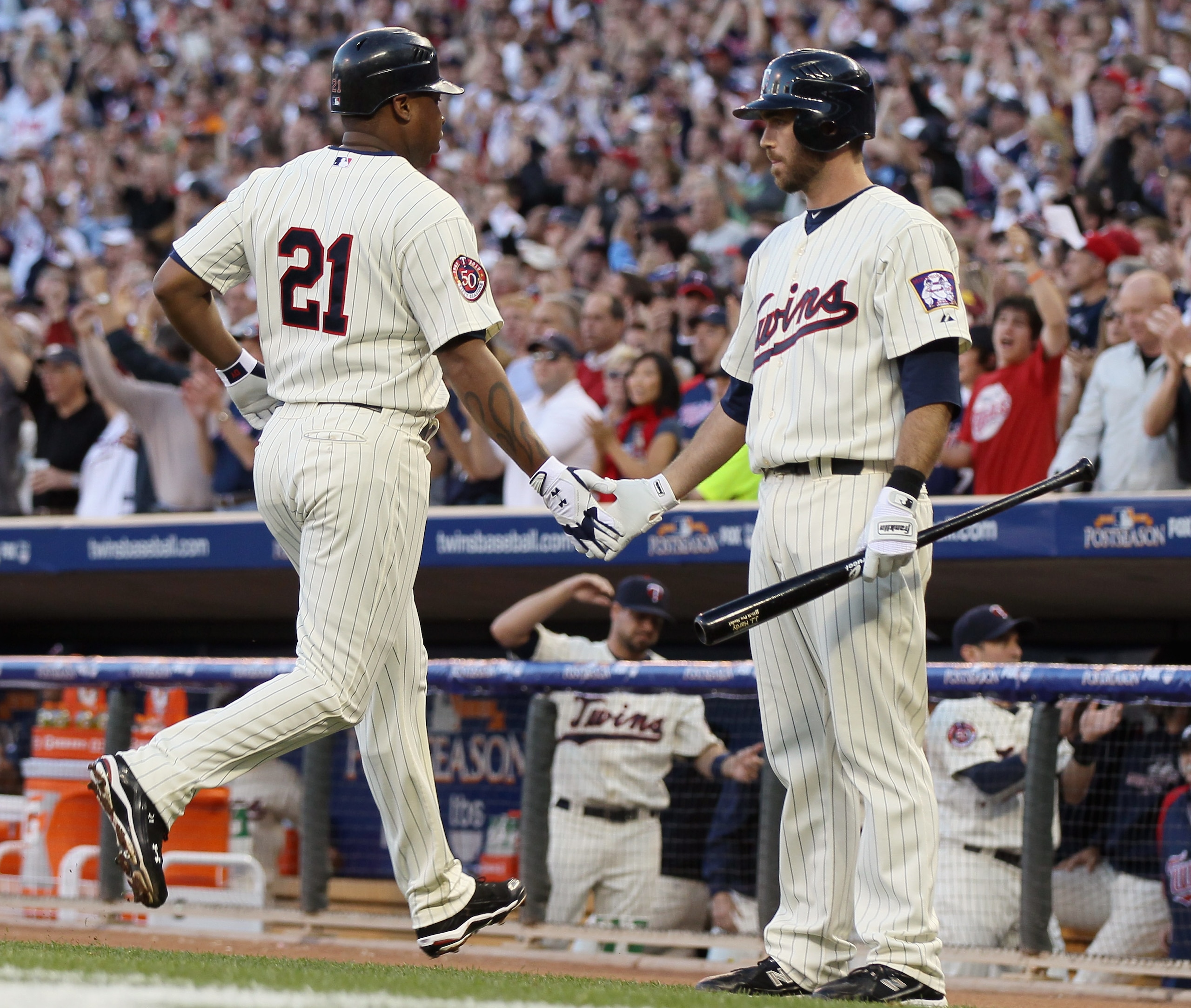 MINNEAPOLIS - OCTOBER 07:  Delmon Young #21 of the Minnesota Twins is congratulated by teammate Jason Kubel #16 after Young scored a run against the New York Yankees during game two of the ALDS on October 7, 2010 at Target Field in Minneapolis, Minnesota.