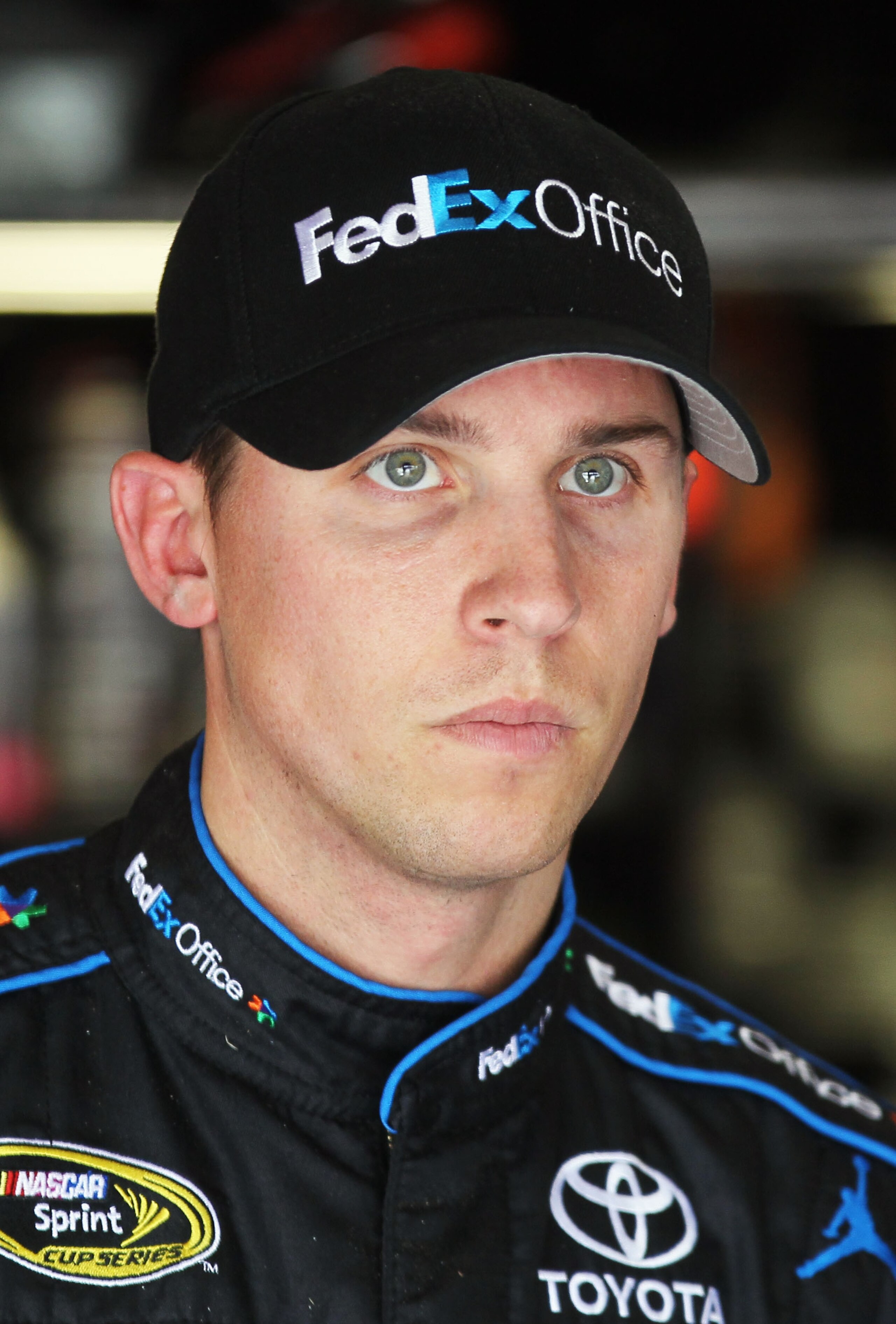 FONTANA, CA - MARCH 26:  Denny Hamlin, driver of the #11 FedEx Toyota, stands in the garage area during practice for the NASCAR Sprint Cup Series Auto Club 400 at Auto Club Speedway on March 26, 2011 in Fontana, California.  (Photo by Jeff Gross/Getty Ima