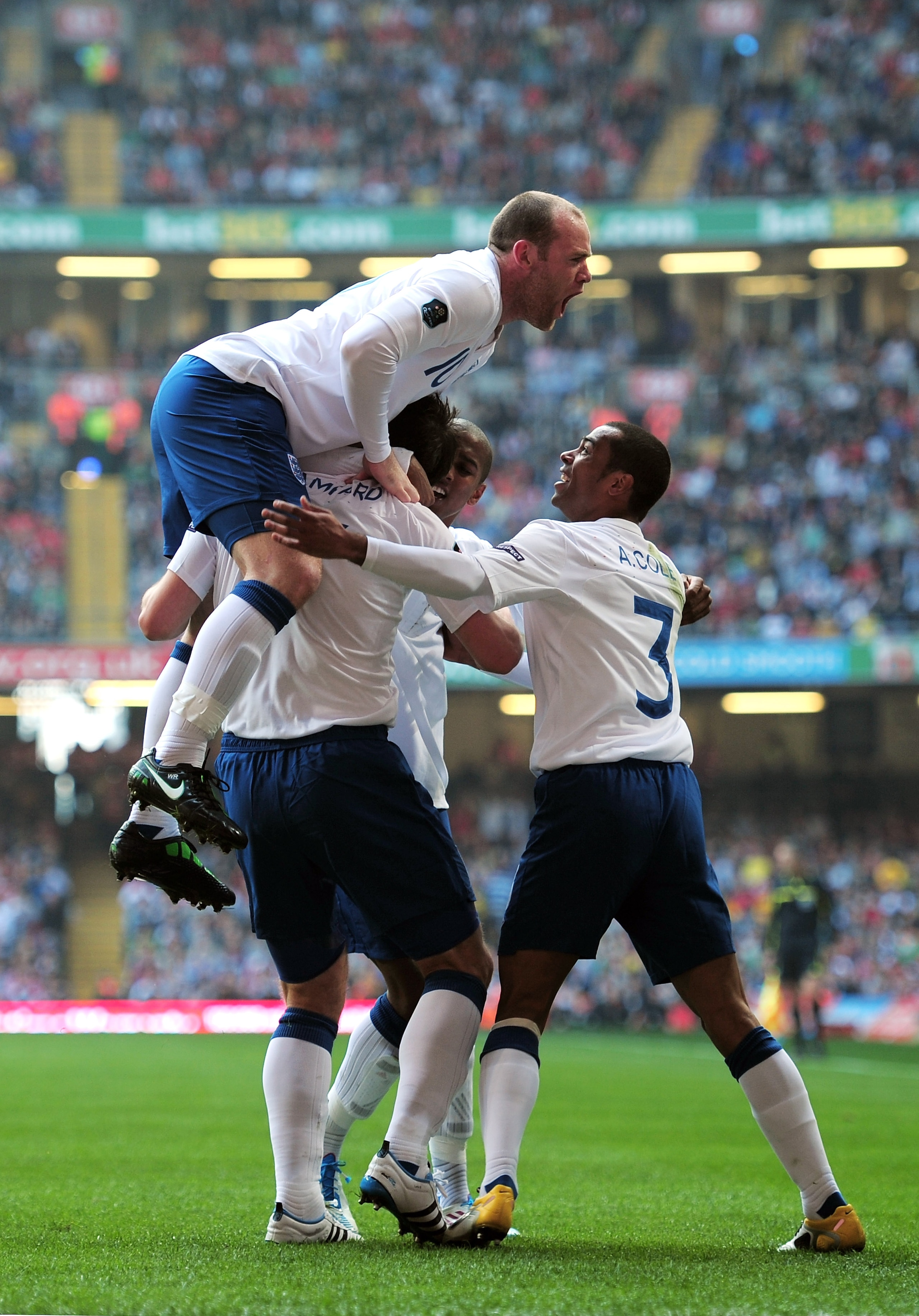 CARDIFF, WALES - MARCH 26: Frank Lampard (obscured) of England celebrates with teammates Wayne Rooney (top) and Ashley Cole (R) after scoring the opening goal from the penalty spot during the UEFA EURO 2012 Group G qualifying match between Wales and Engl CARDIFF, WALES - MARCH 26: Frank Lampard (obscured) of England celebrates with teammates Wayne Rooney (top) and Ashley Cole (R) after scoring the opening goal from the penalty spot during the UEFA EURO 2012 Group G qualifying match between Wales and Engl