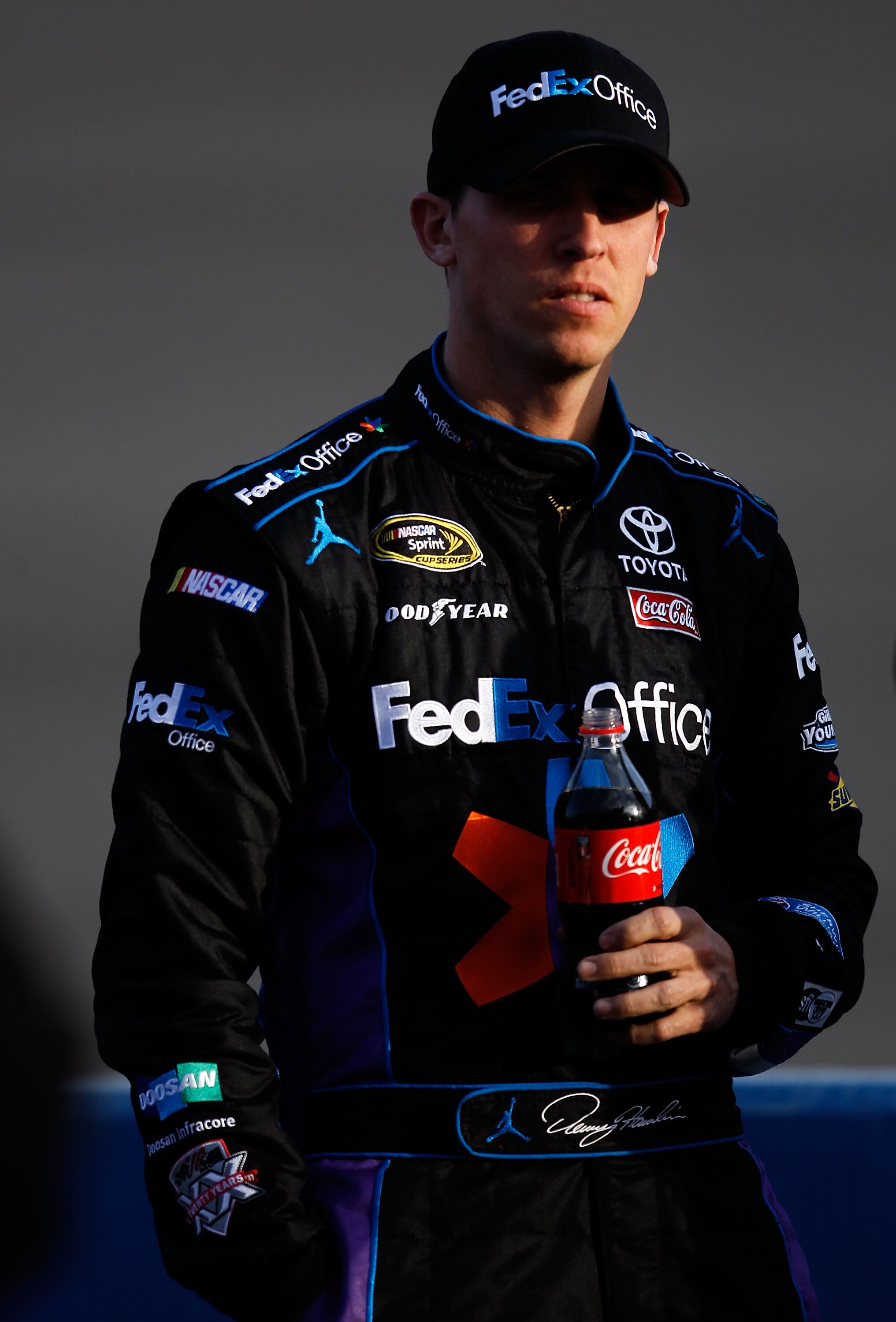 FONTANA, CA - MARCH 25:  Denny Hamlin, driver of the #11 FedEx Toyota, stands on pit road during qualifying for the NASCAR Sprint Cup Series Auto Club 400 at Auto Club Speedway on March 25, 2011 in Fontana, California.  (Photo by Tom Pennington/Getty Imag