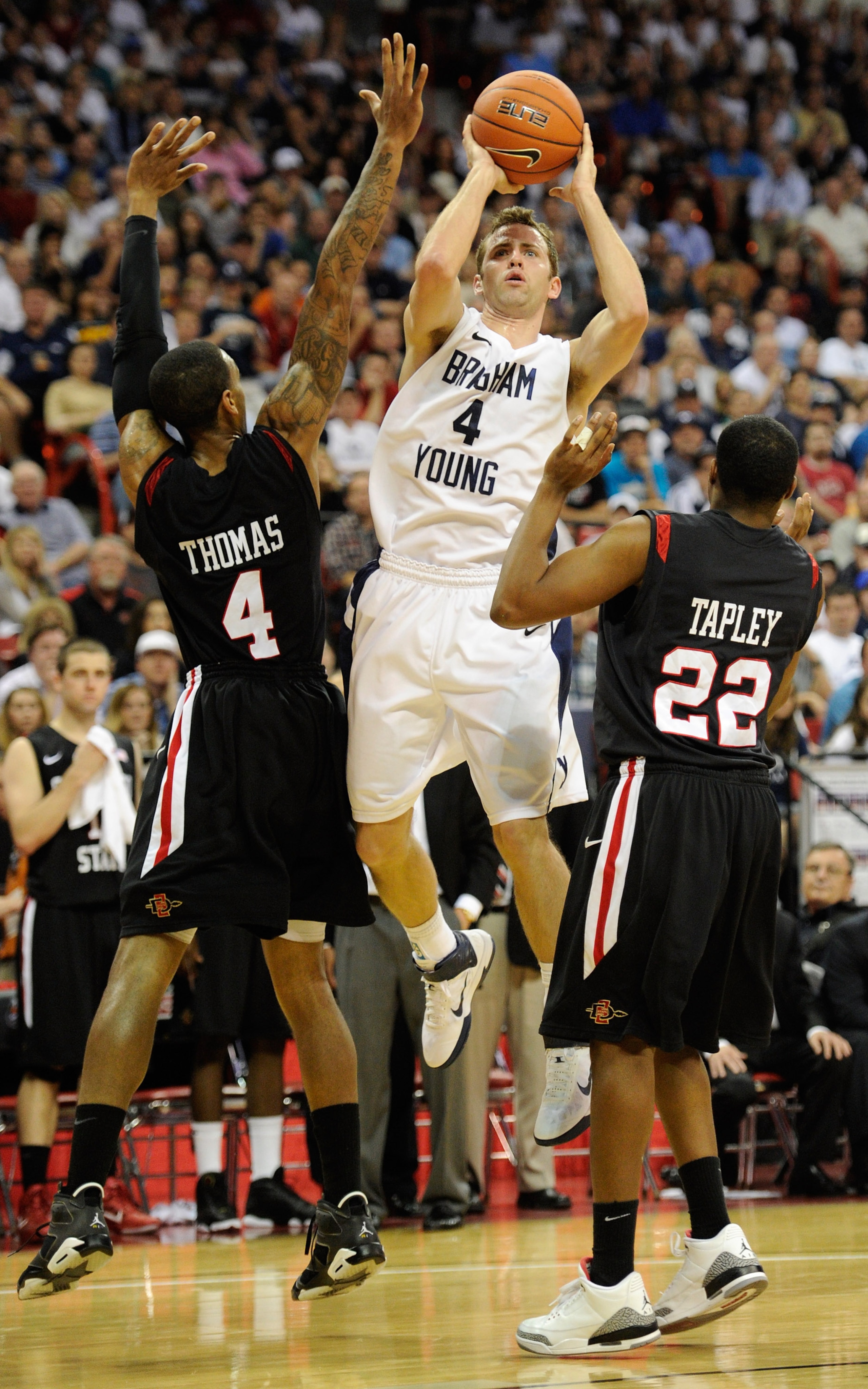 LAS VEGAS, NV - MARCH 12:  Jackson Emery #4 of the Brigham Young University Cougars shoots between Malcolm Thomas #4 and Chase Tapley #22 of the San Diego State Aztecs during the championship game of the Conoco Mountain West Conference Basketball tourname