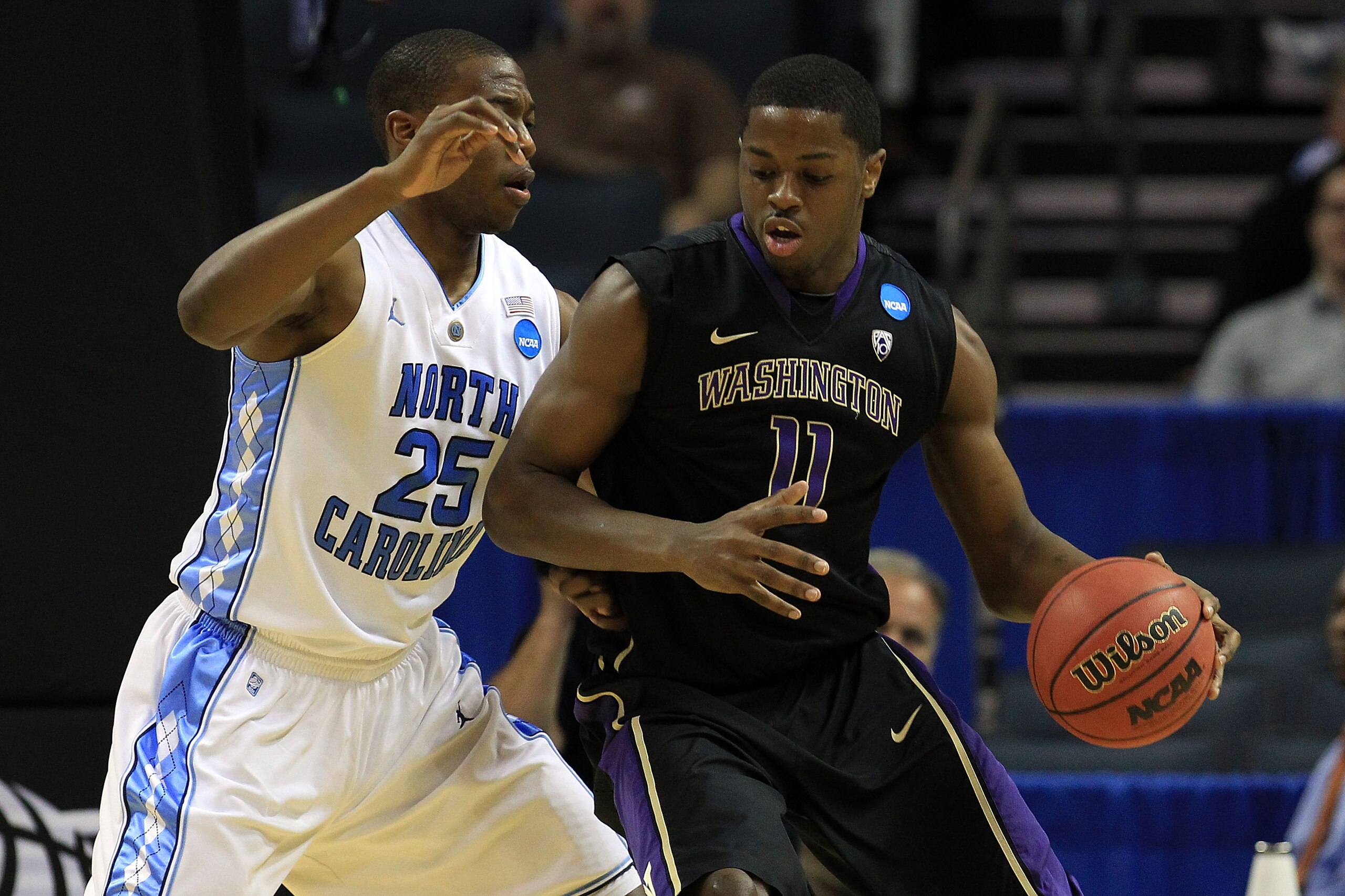 CHARLOTTE, NC - MARCH 20:  Matthew Bryan-Amaning #11 of the Washington Huskies moves the ball against Justin Knox #25 of the North Carolina Tar Heels during the third round of the 2011 NCAA men's basketball tournament at Time Warner Cable Arena on March 2