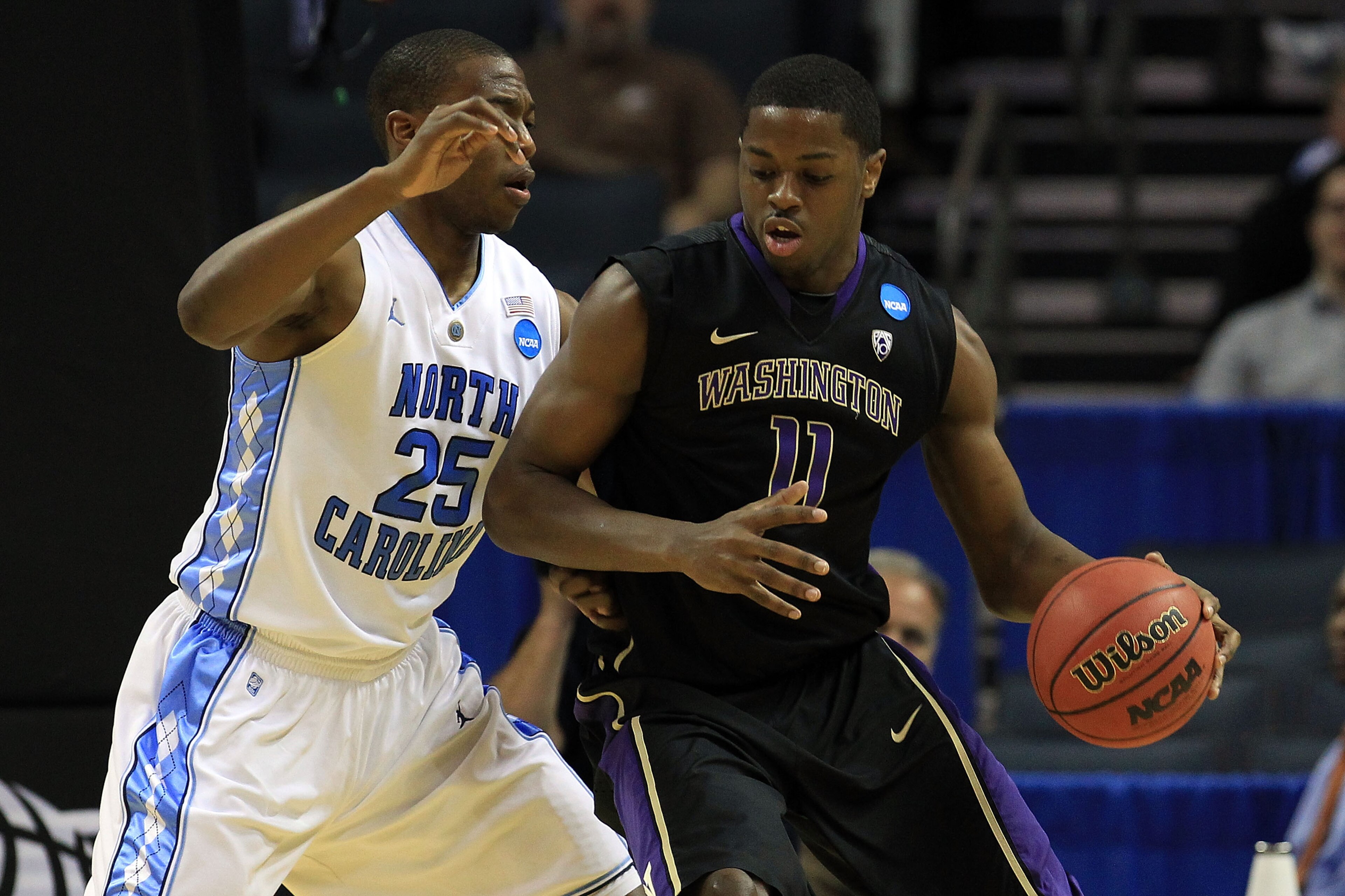 CHARLOTTE, NC - MARCH 20:  Matthew Bryan-Amaning #11 of the Washington Huskies moves the ball against Justin Knox #25 of the North Carolina Tar Heels during the third round of the 2011 NCAA men's basketball tournament at Time Warner Cable Arena on March 2