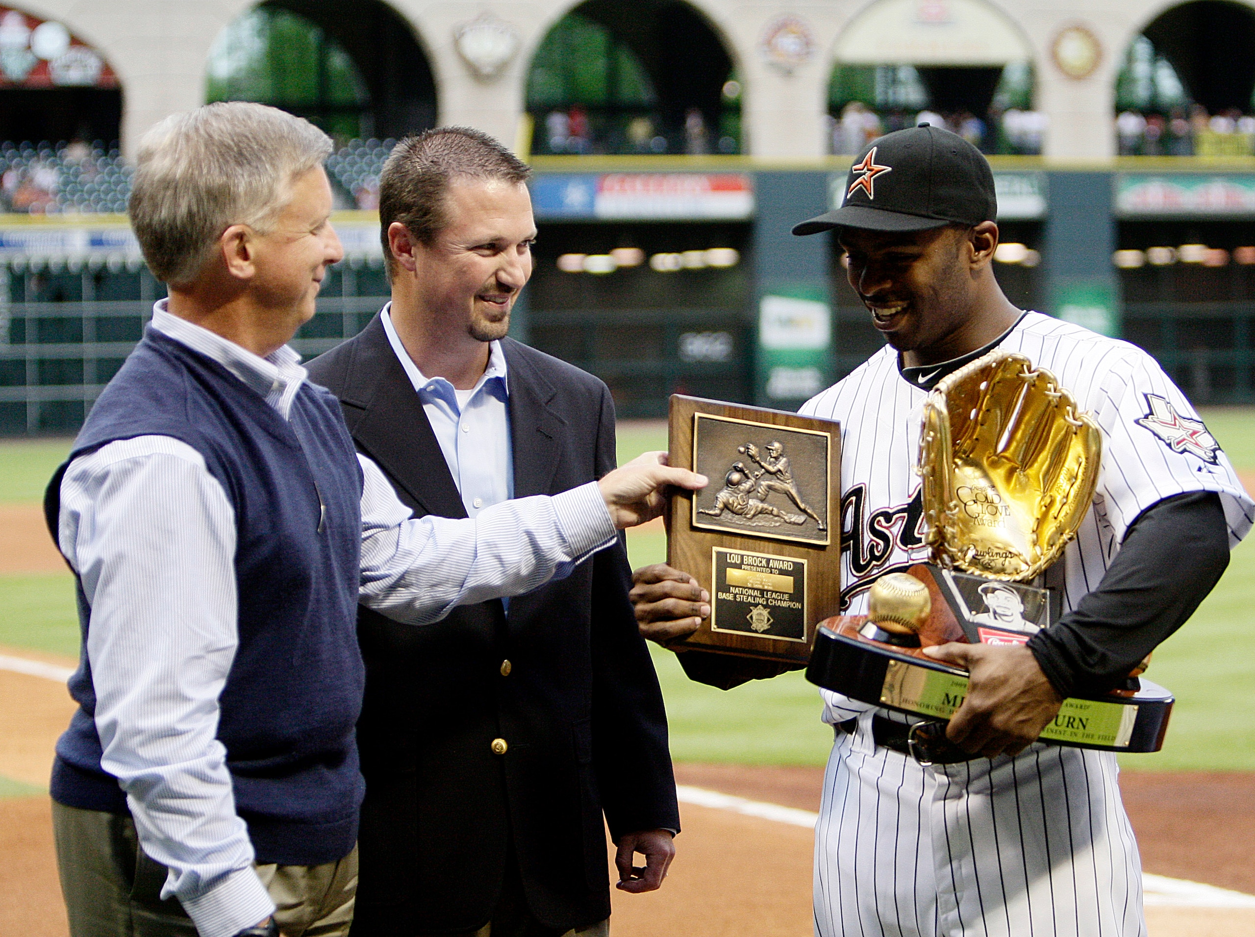 HOUSTON - APRIL 09:  Michael Bourn of the Houston Astos receives from Houston Astros general manager Ed Wade, left,  his Lou Brock Award for most stolen bases in the National League and from Shandy Adelman, center, of Rawlings presented Bourn his gold glo