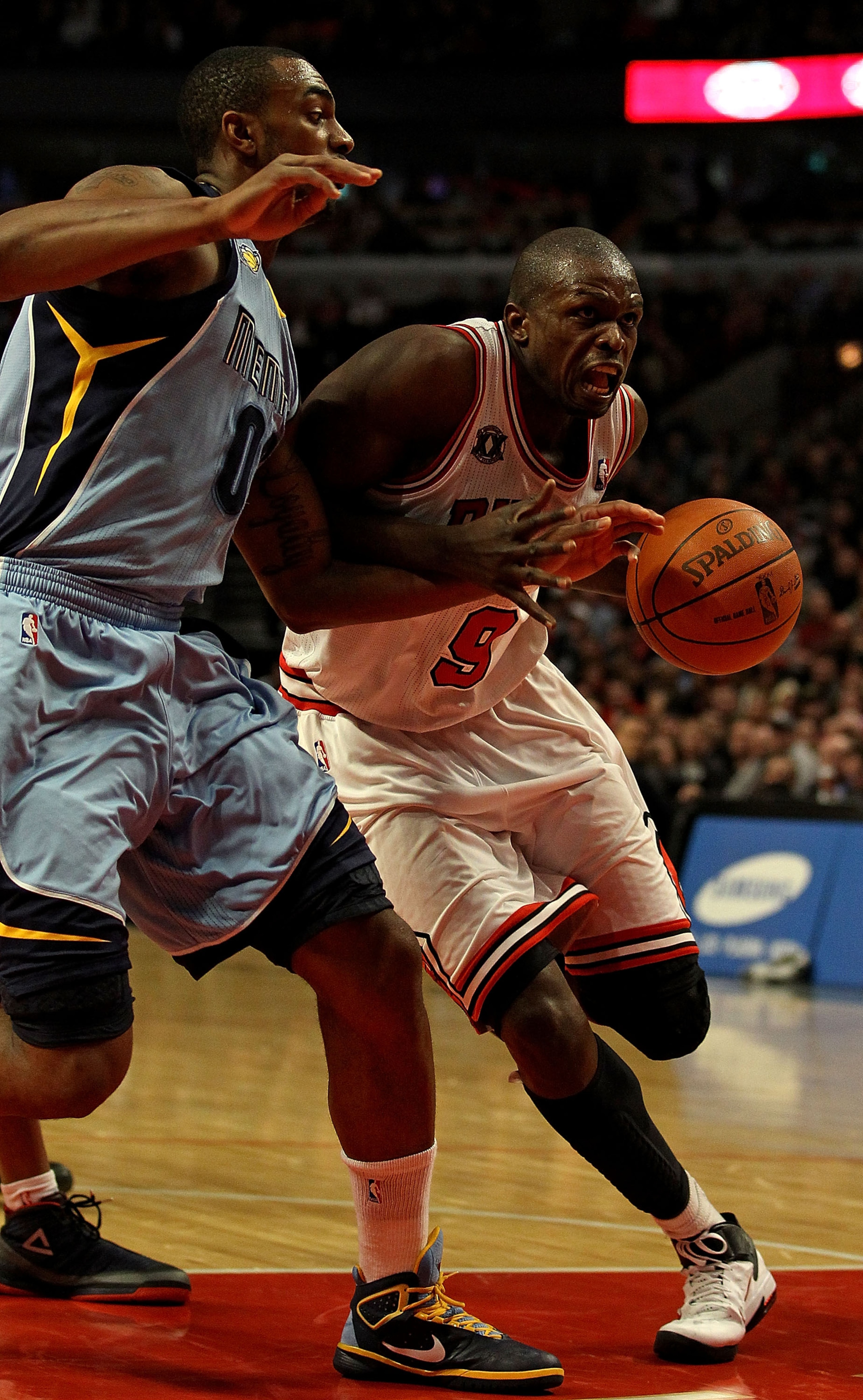 CHICAGO, IL - MARCH 25: Loul  Deng #9 of the Chicago Bulls drives against Darnell Arthur #00 of the Memphis Grizzlies at the United Center on March 25, 2011 in Chicago, Illinois. The Bulls defeated the Grizzlies 99-96. NOTE TO USER: User expressly acknowl
