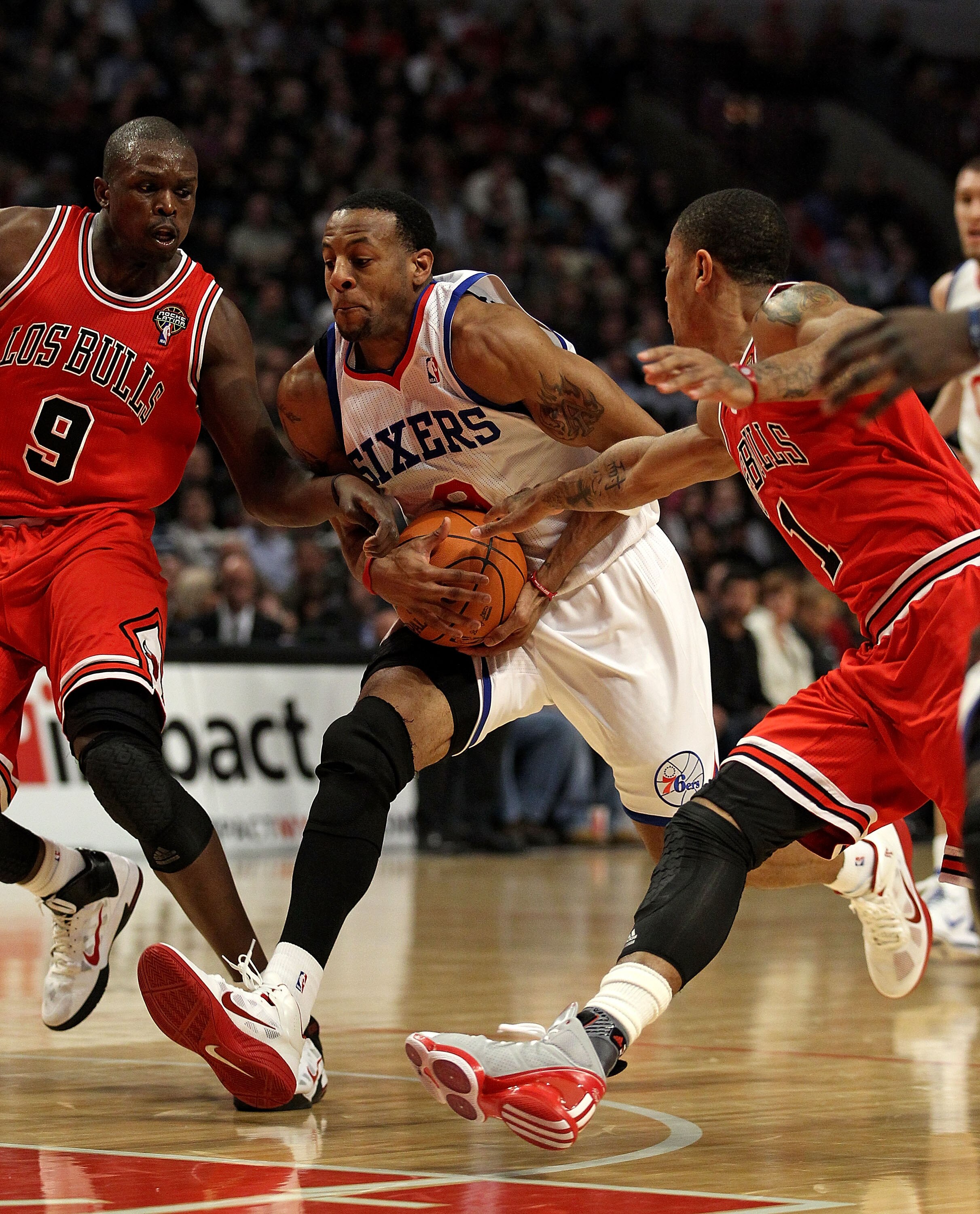 CHICAGO, IL - MARCH 28: Andre Iguodala #9 of the Philadelphia 76ers drives between Loul Deng #9 and Derrick Rose #1 of the Chicago Bulls at the United Center on March 28, 2011 in Chicago, Illinois. NOTE TO USER: User expressly acknowledges and agrees that