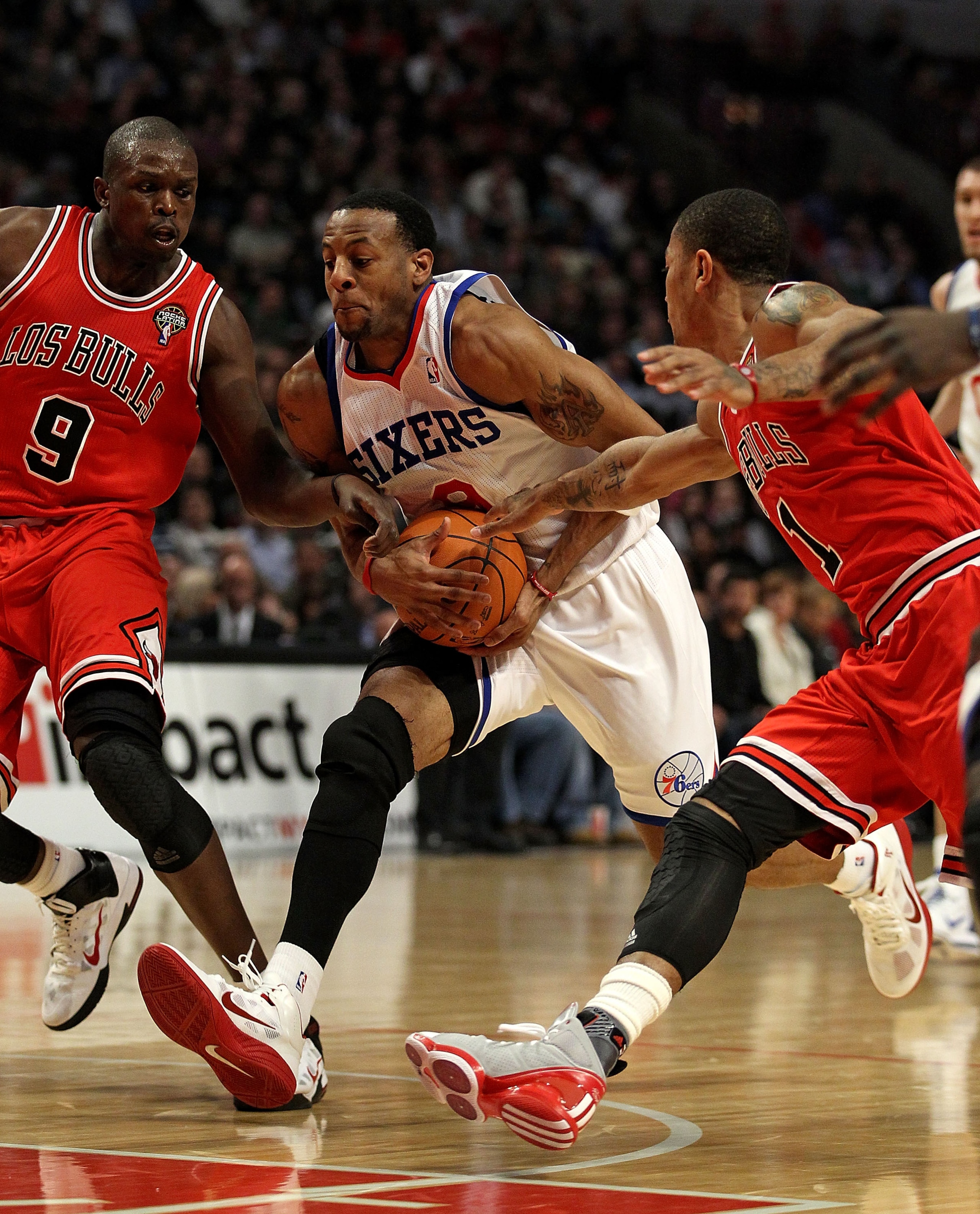 CHICAGO, IL - MARCH 28: Andre Iguodala #9 of the Philadelphia 76ers drives between Loul Deng #9 and Derrick Rose #1 of the Chicago Bulls at the United Center on March 28, 2011 in Chicago, Illinois. NOTE TO USER: User expressly acknowledges and agrees that