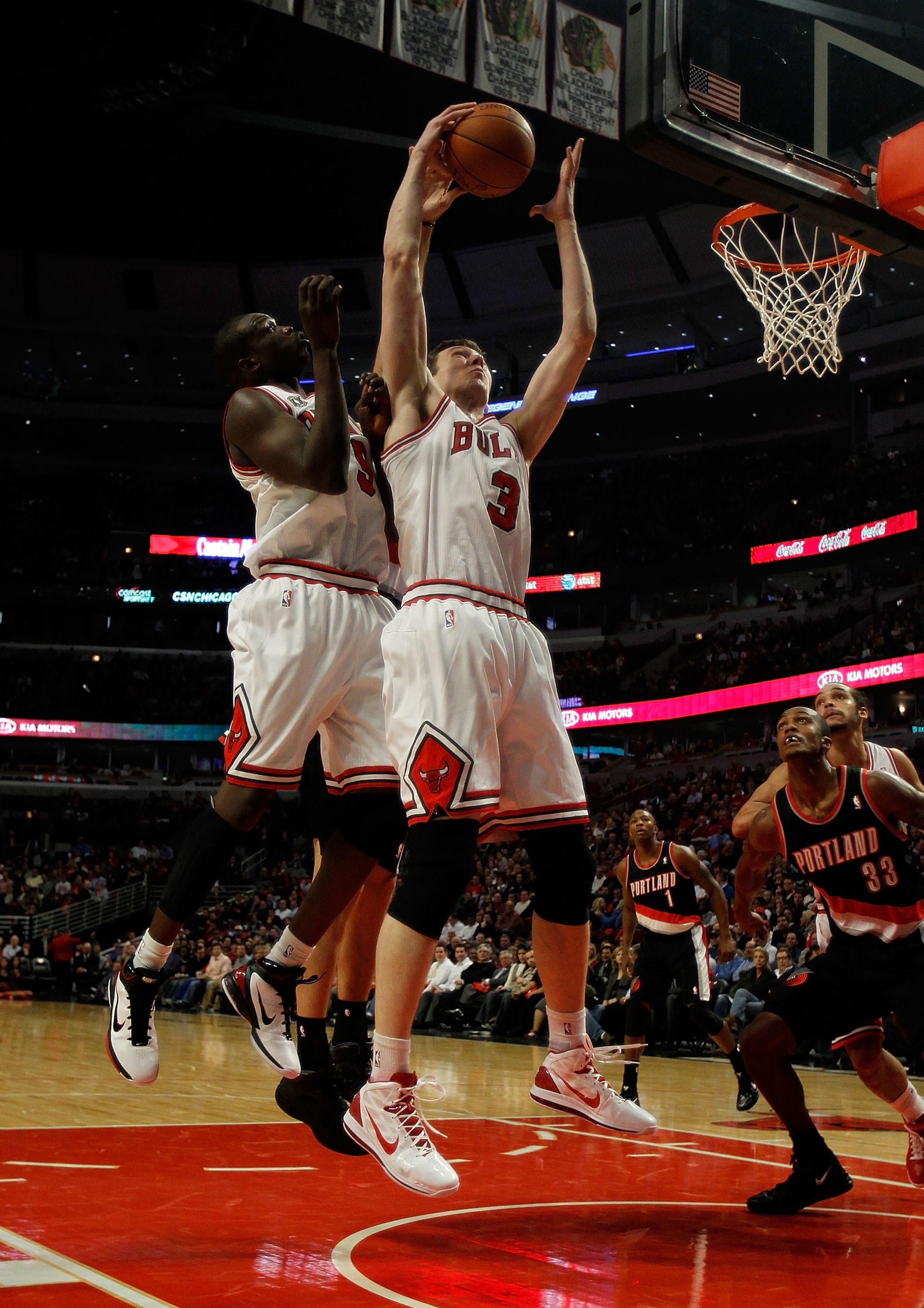 CHICAGO - NOVEMBER 01: Omer Asik #3 of the Chicago Bulls leaps over teammate Loul Deng #9 to grab a rebound against the Portland Trail Blazers at the United Center on November 1, 2010 in Chicago, Illinois. NOTE TO USER: User expressly acknowledges and agr