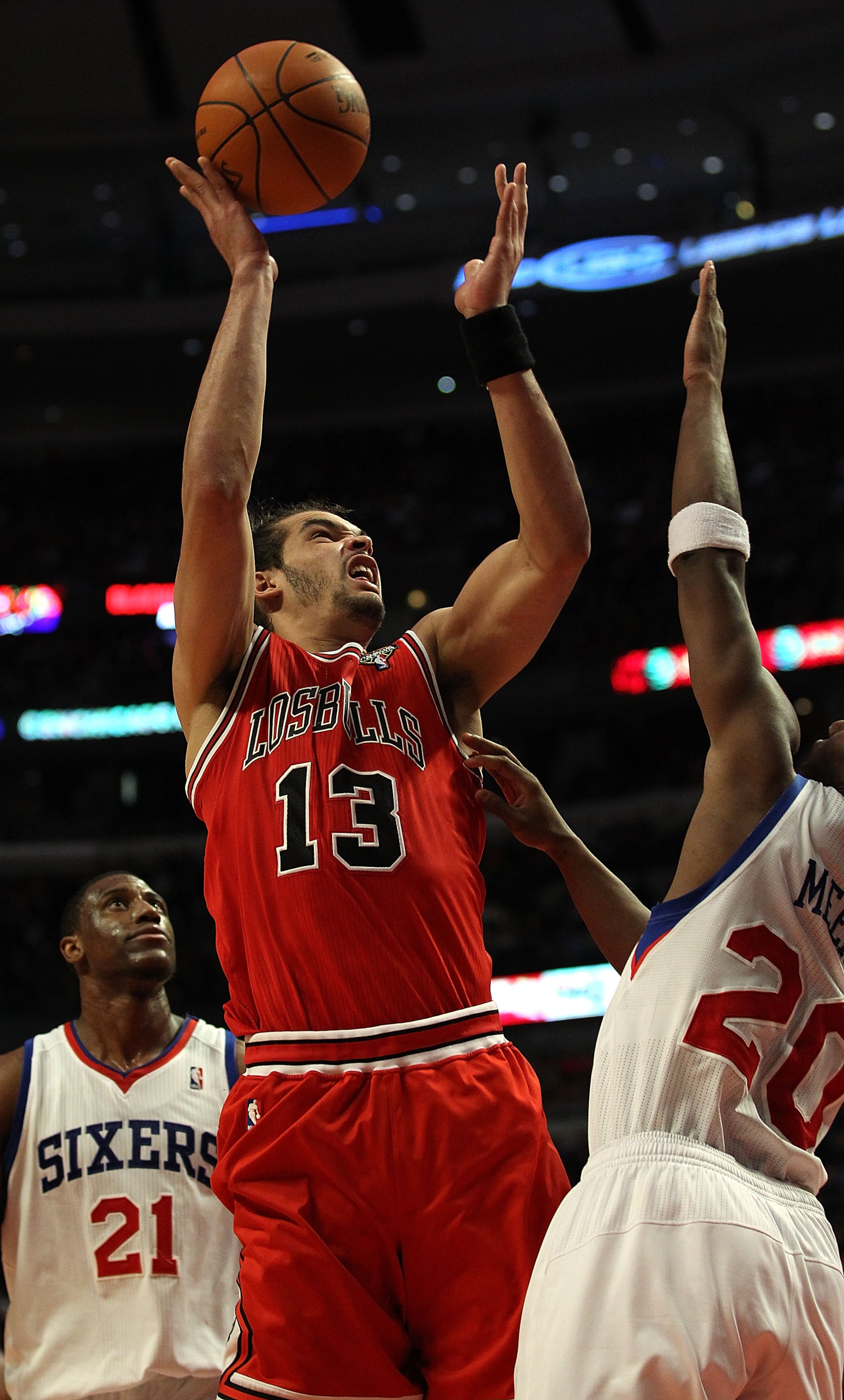 CHICAGO, IL - MARCH 28: Joakim Noah #13 of the Chicago Bulls puts up a shot between Thaddeus Young #21 and Jodie Meeks #20 of the Philadelphia 76ers at the United Center on March 28, 2011 in Chicago, Illinois. The 76ers defeated the Bulls 97-85. NOTE TO U