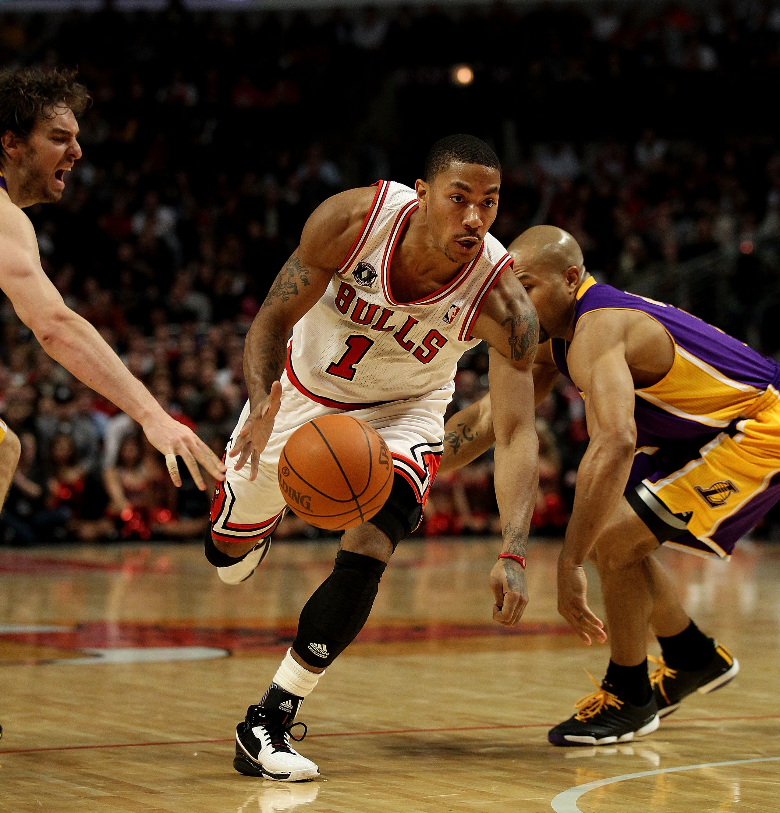 CHICAGO, IL - DECEMBER 10: Derrick Rose #1 of the Chicago Bulls drives between Pau Gasol #16 (L) and Derek Fisher #2 of the Los Angeles Lakers at the United Center on December 10, 2010 in Chicago, Illinois. The Bulls defeated the Lakers 88-84..NOTE TO USE
