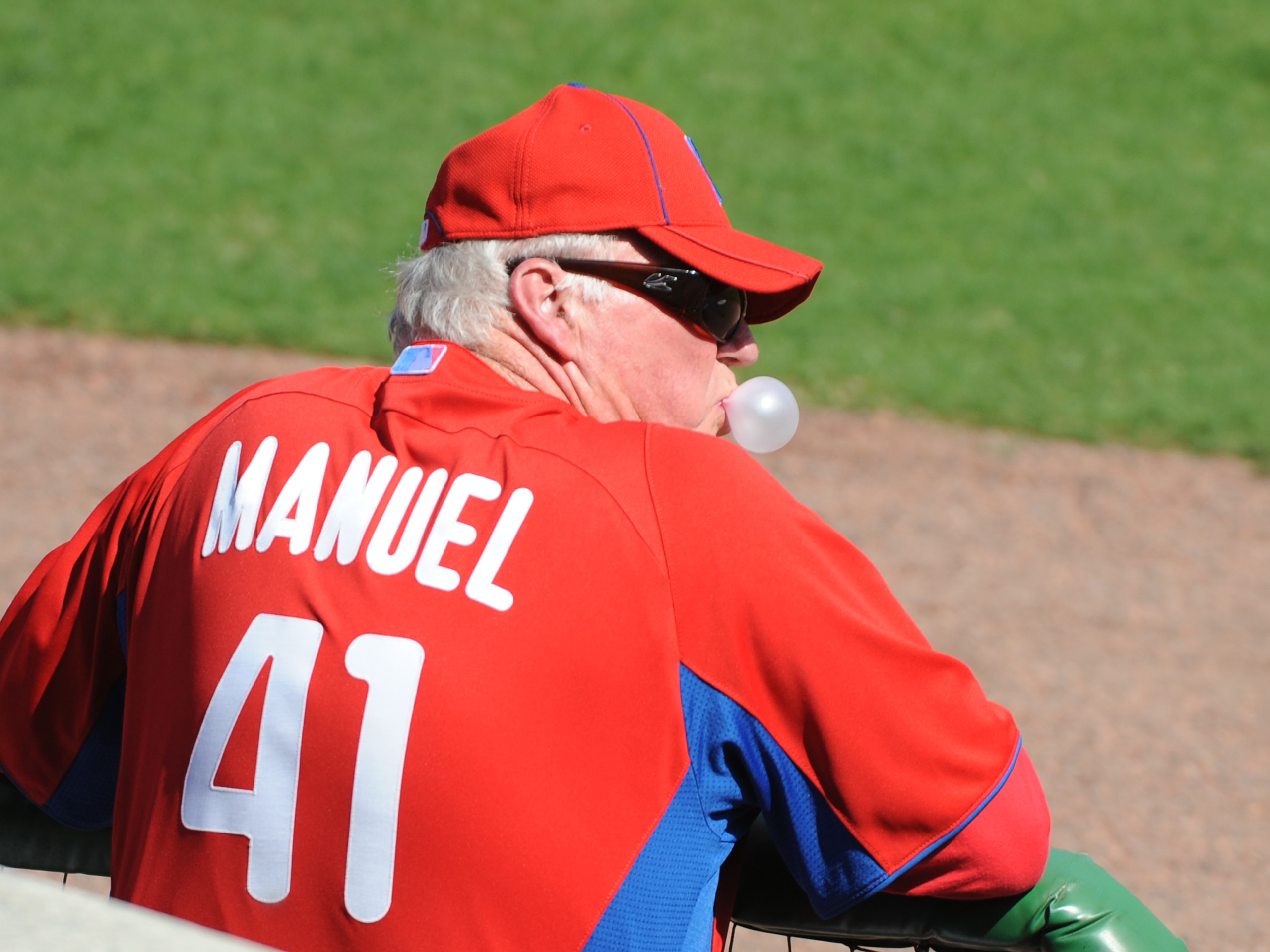 CLEARWATER, FL - FEBRUARY 24:  Manager Charlie Manuel #41 of the Philadelphia Phillies blows a bubble and watches play against the Florida State Seminoles February 24, 2011 at Bright House Field in Clearwater, Florida.  (Photo by Al Messerschmidt/Getty Im