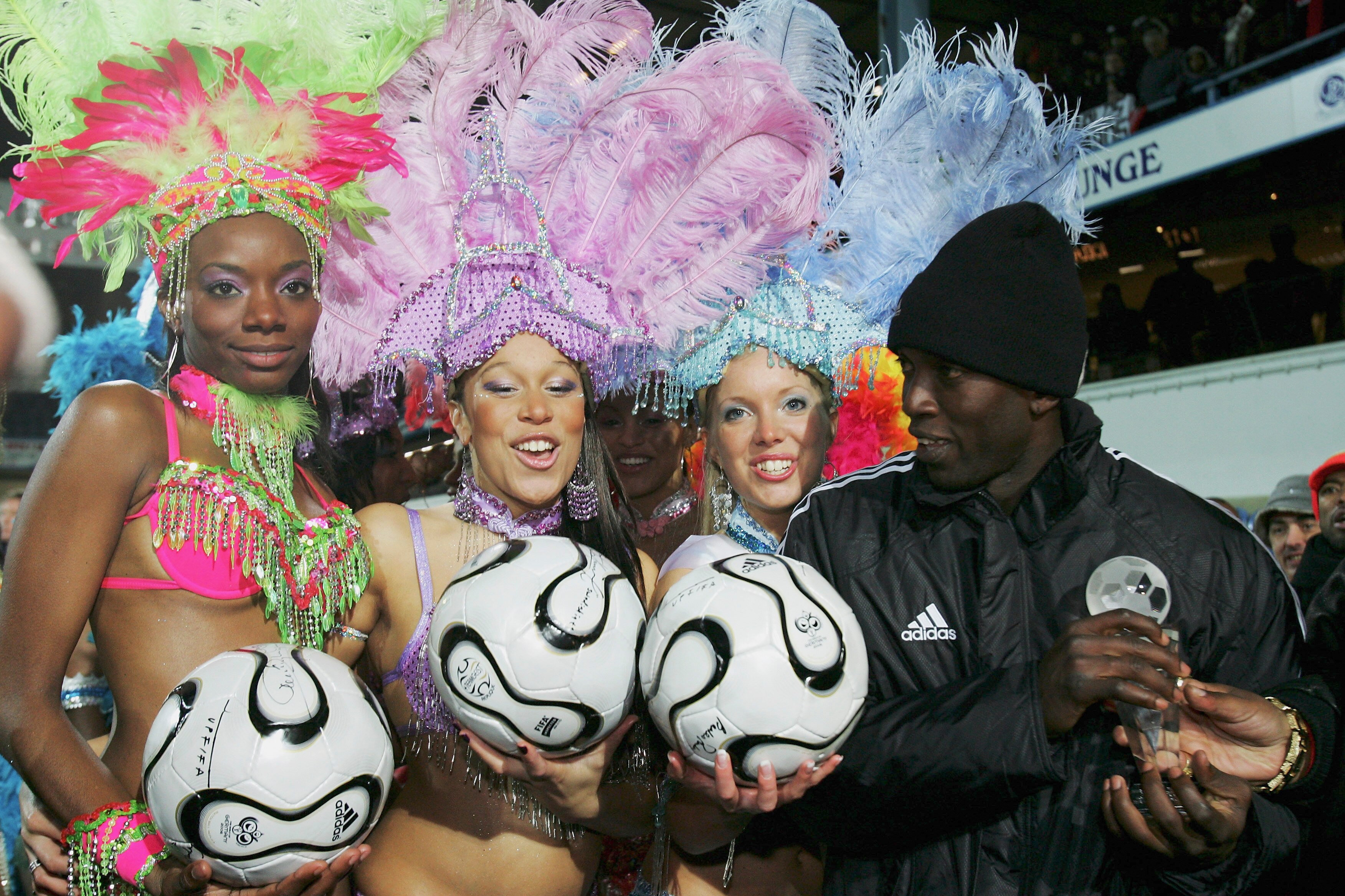 LONDON - FEBRUARY 28:  Dwight Yorke of Trinidad and Tobago meets the half time dancing girls during the International Friendly between Trinidad and Tobago and Iceland at Loftus Road on February 28, 2006 in London, England. (Photo by Bryn Lennon/Getty Imag