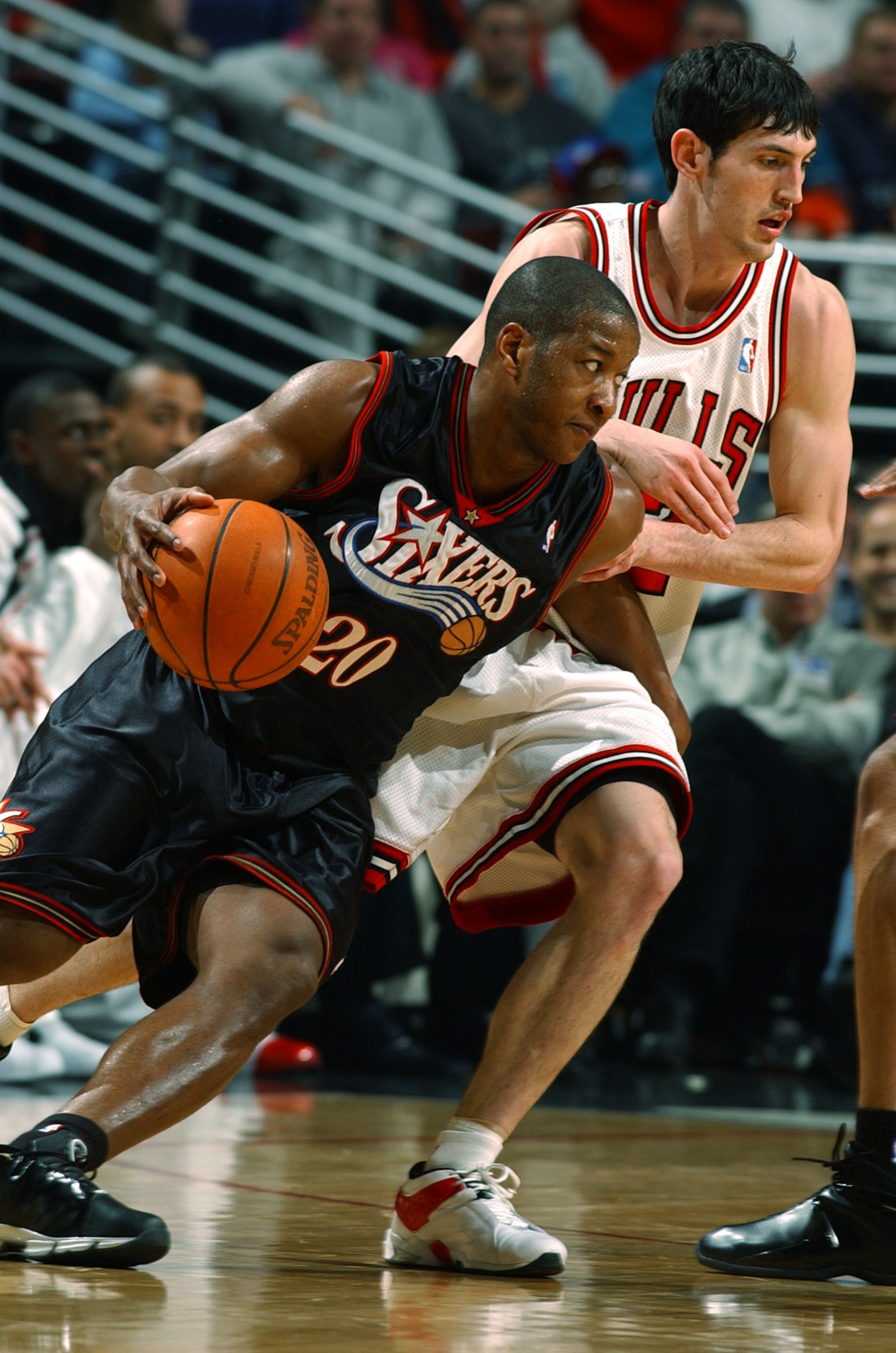 CHICAGO - MARCH 9: Guard Eric Snow #20 of the Philadelphia 76ers drives around guard Kirk Hinrich #12 of the Chicago Bulls during a game on March 9, 2004 at the United Center in Chicago, Illinois. The 76ers defeated the Bulls 89-81. NOTE TO USER: User exp