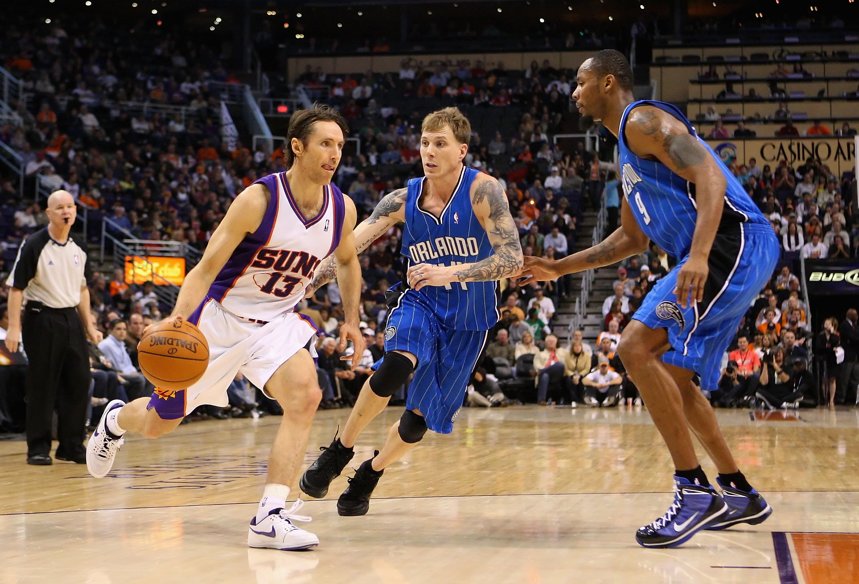 PHOENIX - DECEMBER 11:  Steve Nash #13 of the Phoenix Suns handles the ball under pessure from Jason Williams #44 of the Orlando Magic during the NBA game at US Airways Center on December 11, 2009 in Phoenix, Arizona. The Suns defeated the Magic 106-103.