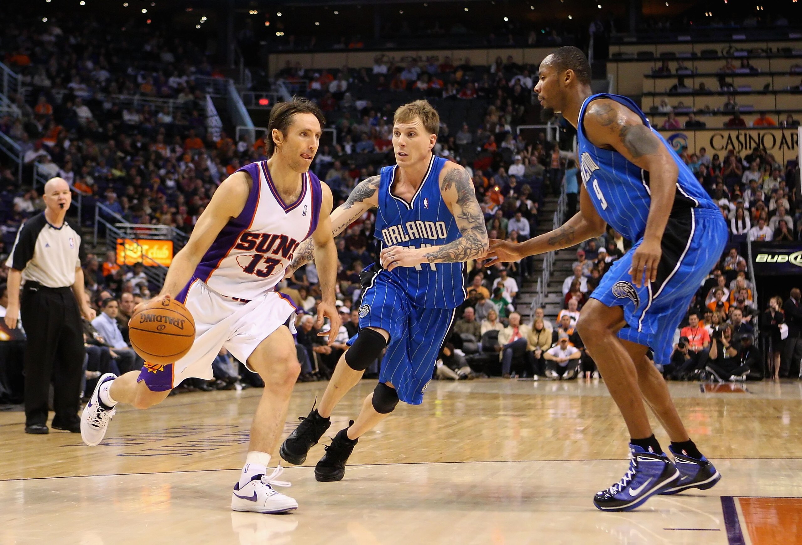 PHOENIX - DECEMBER 11:  Steve Nash #13 of the Phoenix Suns handles the ball under pessure from Jason Williams #44 of the Orlando Magic during the NBA game at US Airways Center on December 11, 2009 in Phoenix, Arizona. The Suns defeated the Magic 106-103.