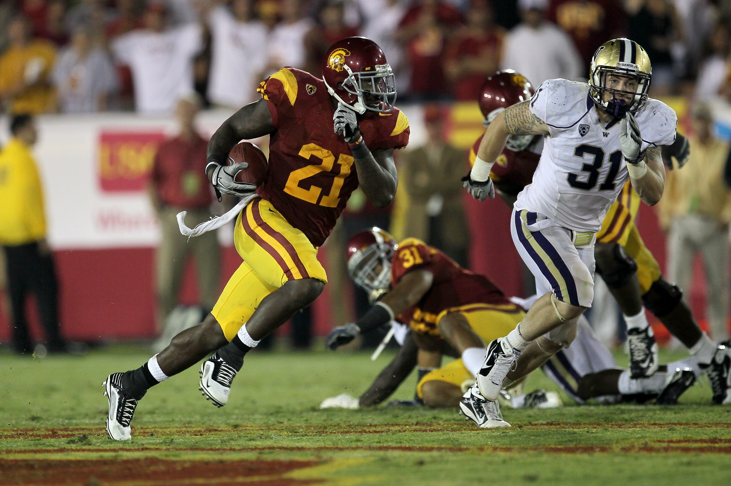 LOS ANGELES, CA - OCTOBER 02:  Running back Allen Bradford #21 of the USC Trojans carries the ball against linebacker Cort Dennison #31 of the Washington Huskies at the Los Angeles Memorial Coliseum on October 2, 2010 in Los Angeles, California.  Washingt
