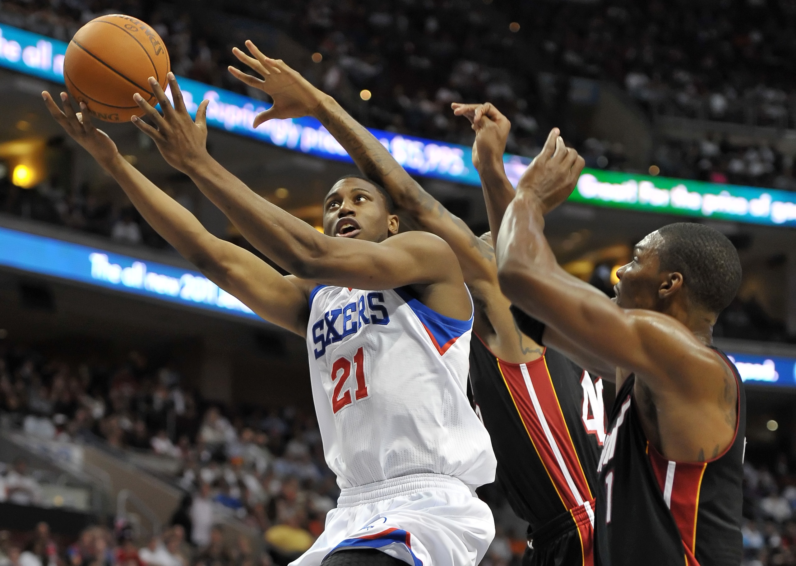 PHILADELPHIA - OCTOBER 27:  Thaddeus Young #21 of the Philadelphia 76ers lays up a shot past Udonis Haslem #40 and Chris Bosh #1 of the Miami Heat at the Wells Fargo Center on October 27, 2010 in Philadelphia, Pennsylvania. NOTE TO USER: User expressly ac