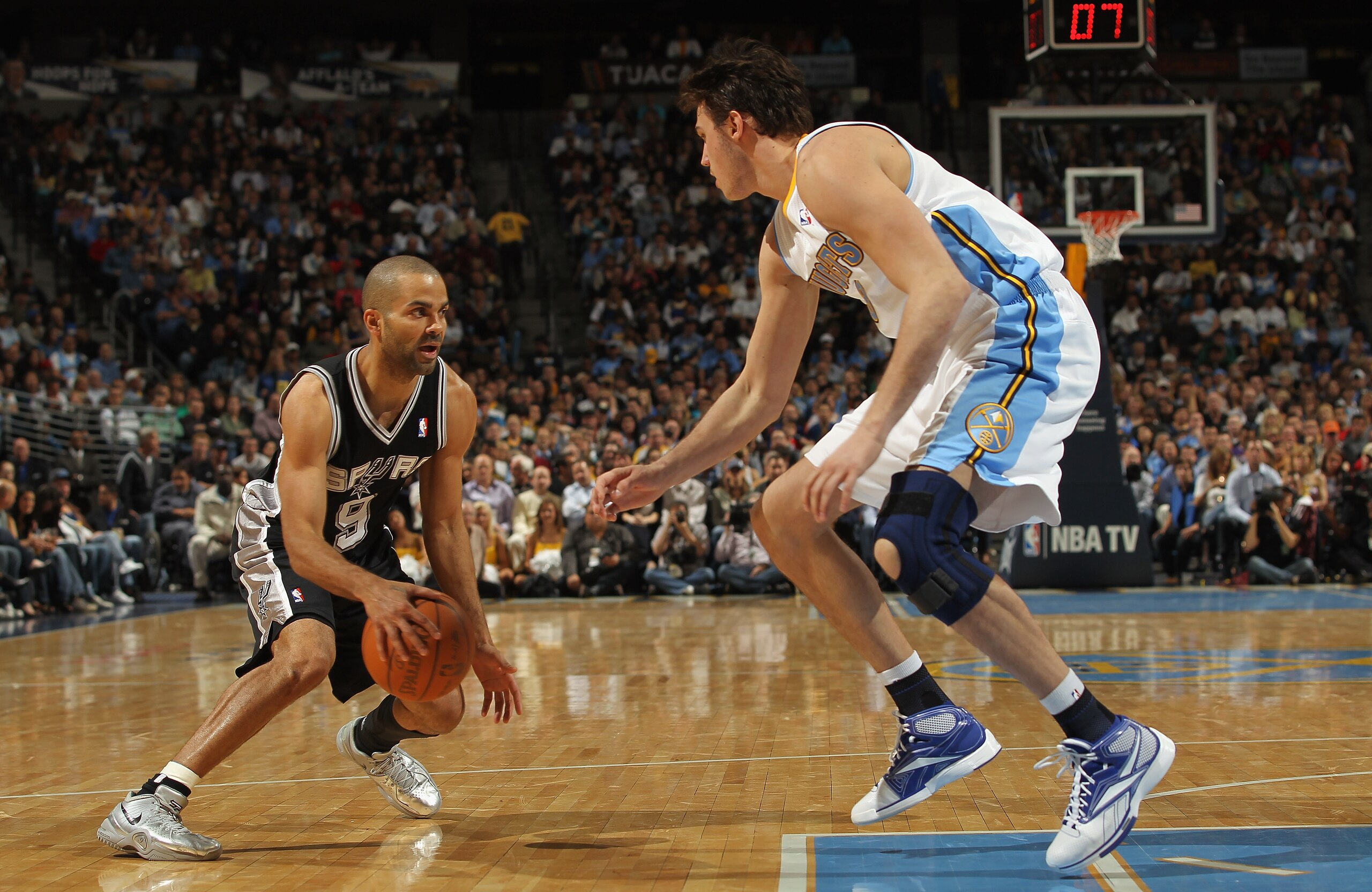 DENVER, CO - MARCH 23:  Tony Parker #9 of the San Antonio Spurs dribbles the ball against Danilo Gallinari the Denver Nuggets at the Pepsi Center on March 23, 2011 in Denver, Colorado. The Nuggets defeated the Spurs 115-112. NOTE TO USER: User expressly a