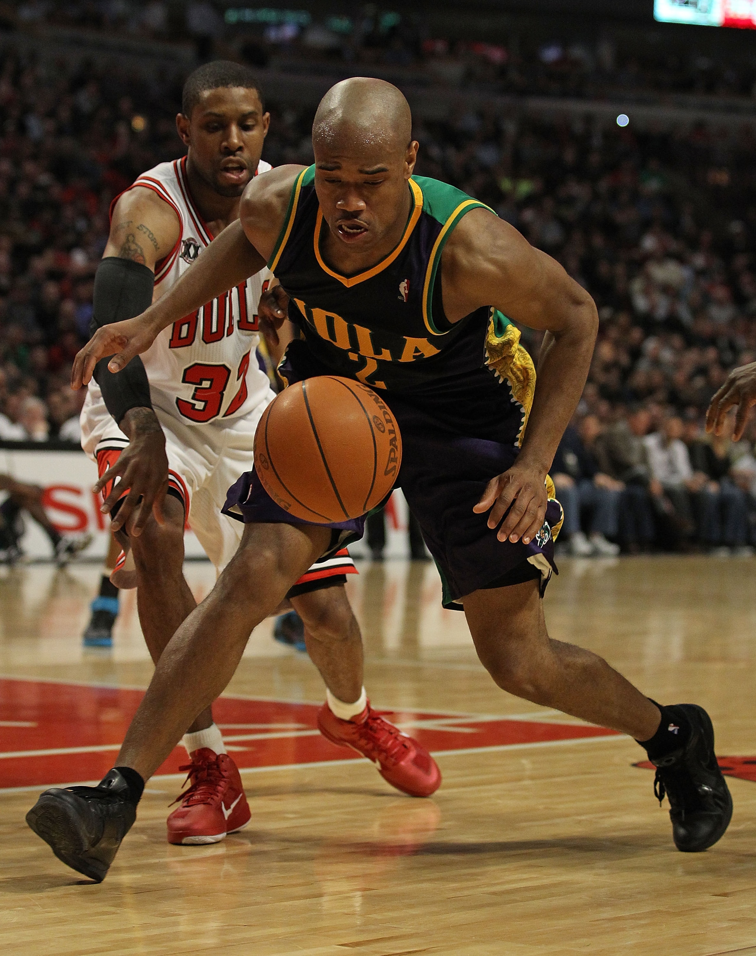 CHICAGO, IL - MARCH 07: Jarrett Jack #2 of the New Orleans Hornets moves to a loose ball in front of C.J. Watson #32 of the Chicago Bulls at the United Center on March 7, 2011 in Chicago, Illinois. The Bulls defeated the Hornets 85-77. NOTE TO USER: User