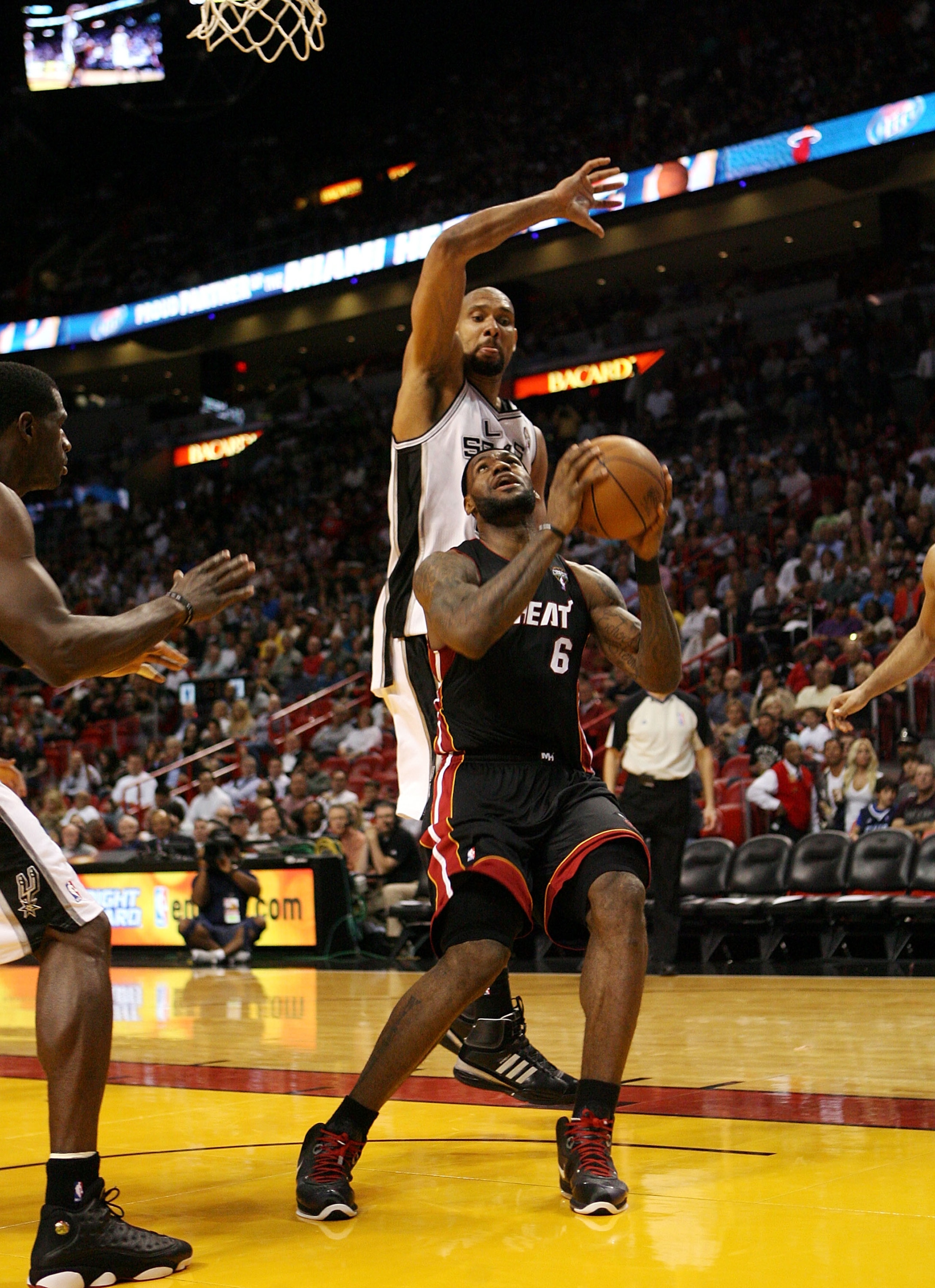 MIAMI - MARCH 14:  Forward LeBron James #6 of the Miami Heat drives against Center Tim Duncan #21 of the San Antonio Spurs at American Airlines Arena on March 14, 2011 in Miami, Florida. The Heat defeated the Spurs 110-80. NOTE TO USER: User expressly ack