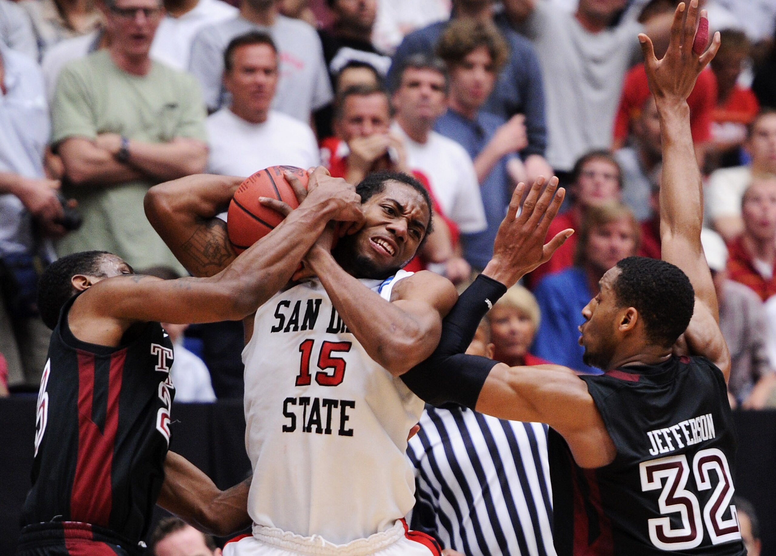 TUCSON, AZ - MARCH 19:  Ramone Moore #23 and Rahlir Jefferson #32 of the Temple Owls attempt to steal from Kawhi Leonard #15 of the San Diego State Aztecs in double overtime during the third round of the 2011 NCAA men's basketball tournament at McKale Cen