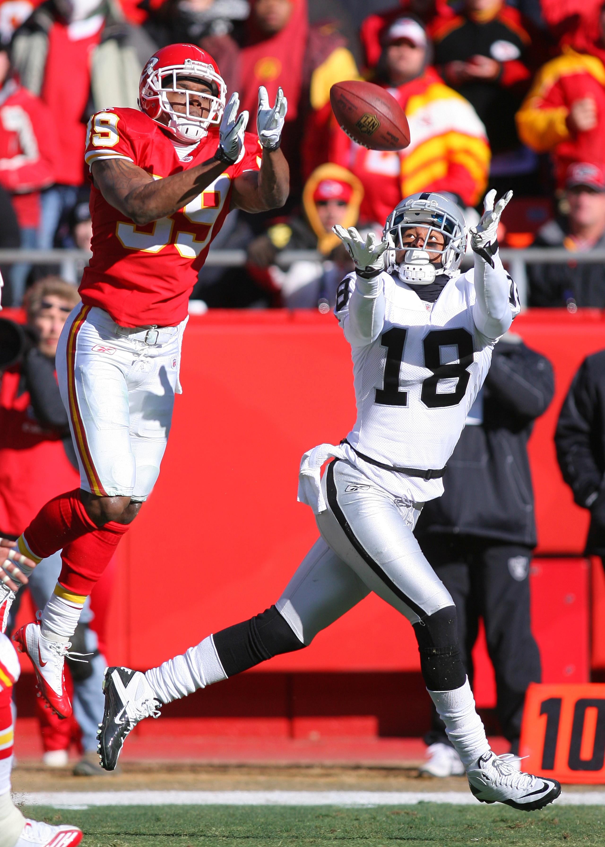 KANSAS CITY, MO - JANUARY 02:  Wide receiver Louis Murphy #18 of the Oakland Raiders catches a pass while defended by cornerback Brandon Carr #39 of the Kansas City Chiefs in a game at Arrowhead Stadium on January 2, 2011 in Kansas City, Missouri.  (Photo