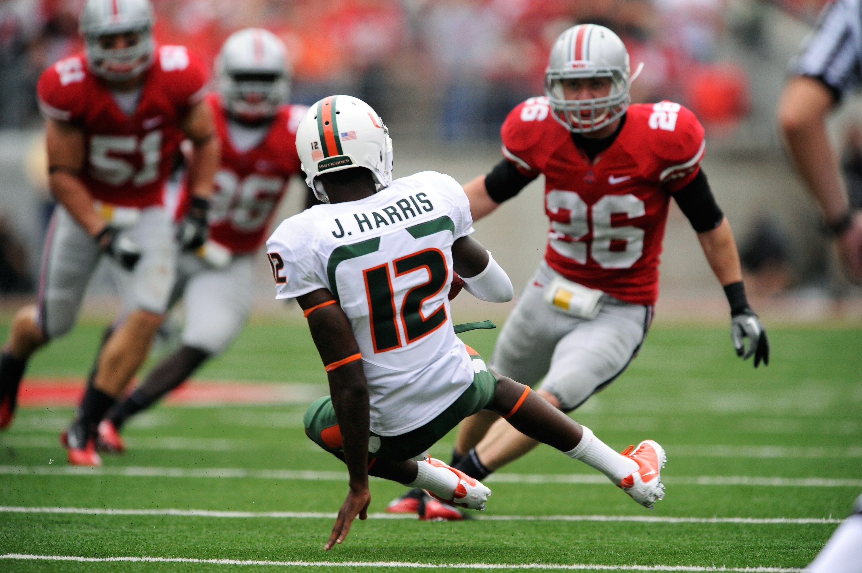COLUMBUS, OH - SEPTEMBER 11:  Quarterback Jacory Harris #12 of the Miami Hurricanes slides in to avoid be tackled by Tyler Moeller #26 of the Ohio State Buckeyes at Ohio Stadium on September 11, 2010 in Columbus, Ohio.  (Photo by Jamie Sabau/Getty Images)