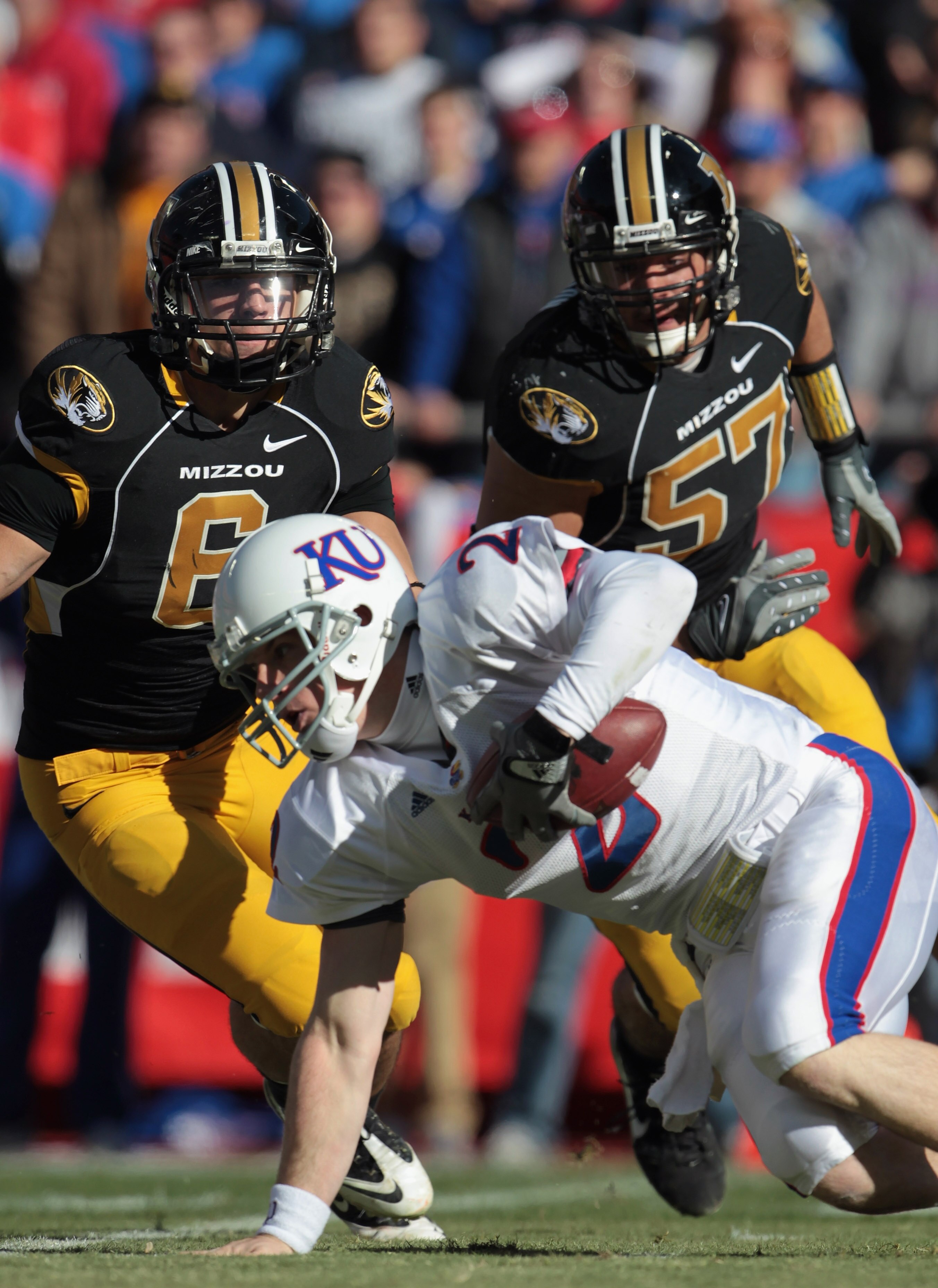 KANSAS CITY, MO - NOVEMBER 27:  Quarterback Jordan Webb #2 of the Kansas Jayhawks is sacked by Andrew Gochkar #6 and Brad Madison #57 of the Missouri Tigers during the game on November 27, 2010 at Arrowhead Stadium in Kansas City, Missouri.  (Photo by Jam