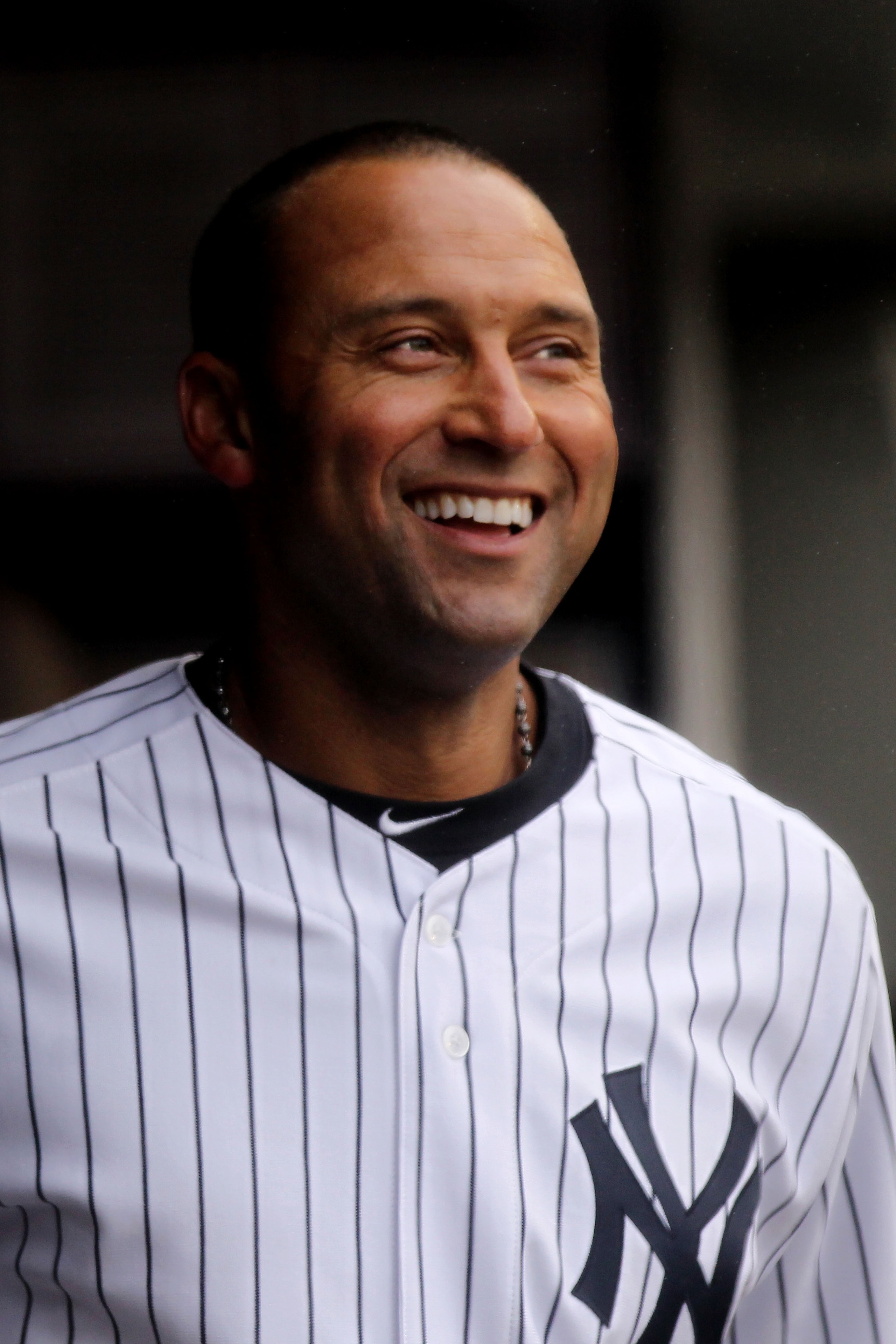 NEW YORK, NY - MARCH 31:  Derek Jeter #2 of the New York Yankees smiles as he looks on from the dugout during the game against the Detroit Tigers on Opening Day at Yankee Stadium on March 31, 2011 in New York City.  (Photo by Nick Laham/Getty Images)