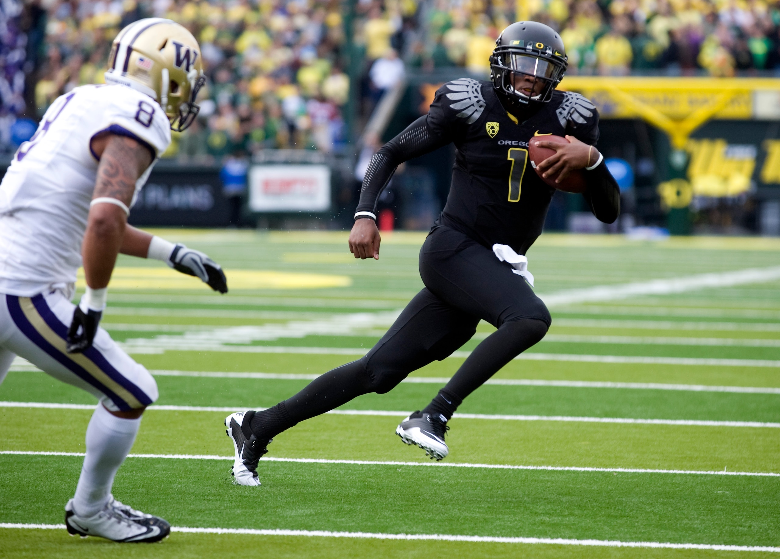 EUGENE, OR - NOVEMBER 06: Quarterback Darron Thomas #1 of the Oregon Ducks tries to elude the pursuit of safety Nate Williams #8 of the Washington Huskies in the second quarter of the game against at Autzen Stadium on November 6, 2010 in Eugene, Oregon. T