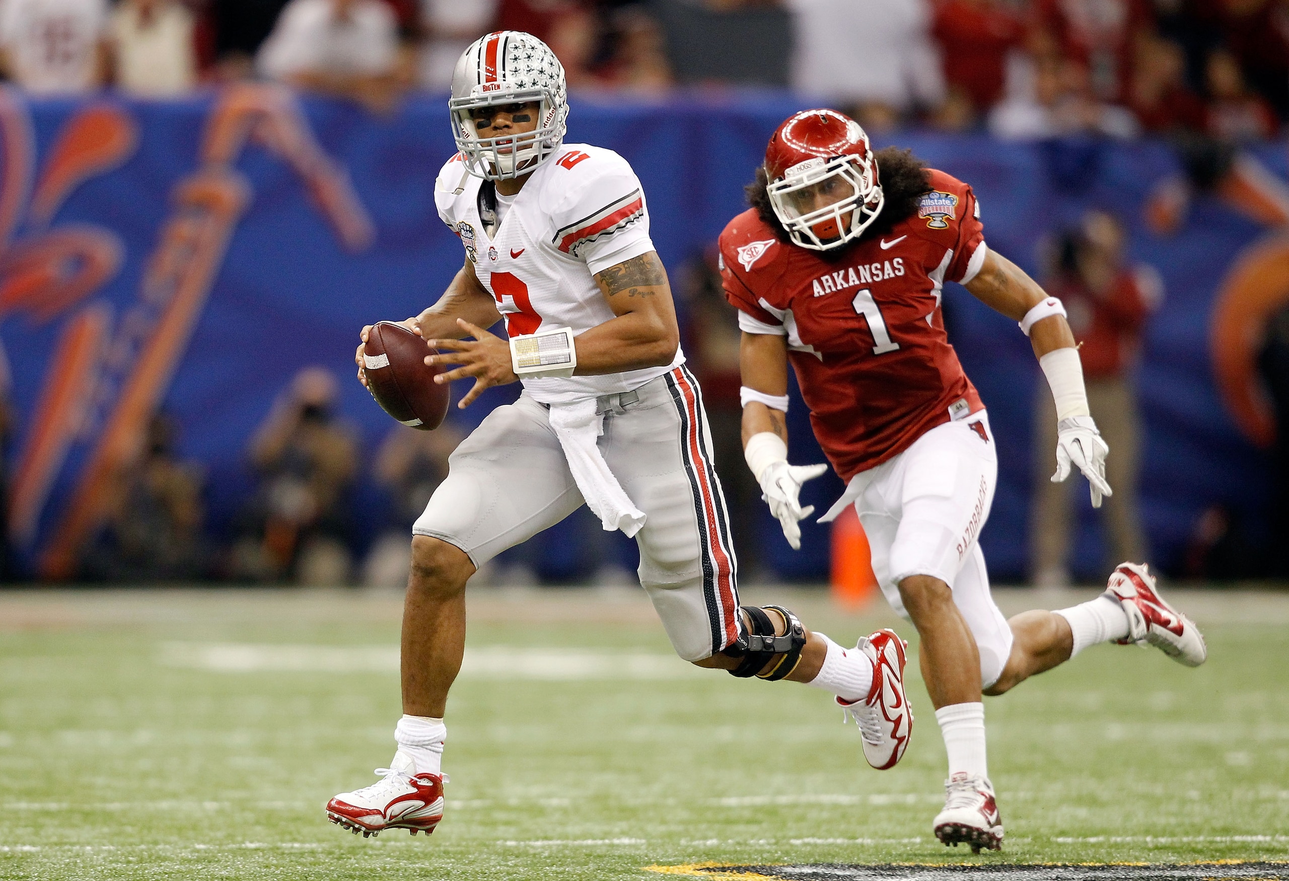 NEW ORLEANS, LA - JANUARY 04:  Terrelle Pryor #2 of the Ohio State Buckeyes scrambles as he is chased by Anthony Leon #1 of the Arkansas Razorbacks in the second quarter during the Allstate Sugar Bowl at the Louisiana Superdome on January 4, 2011 in New O