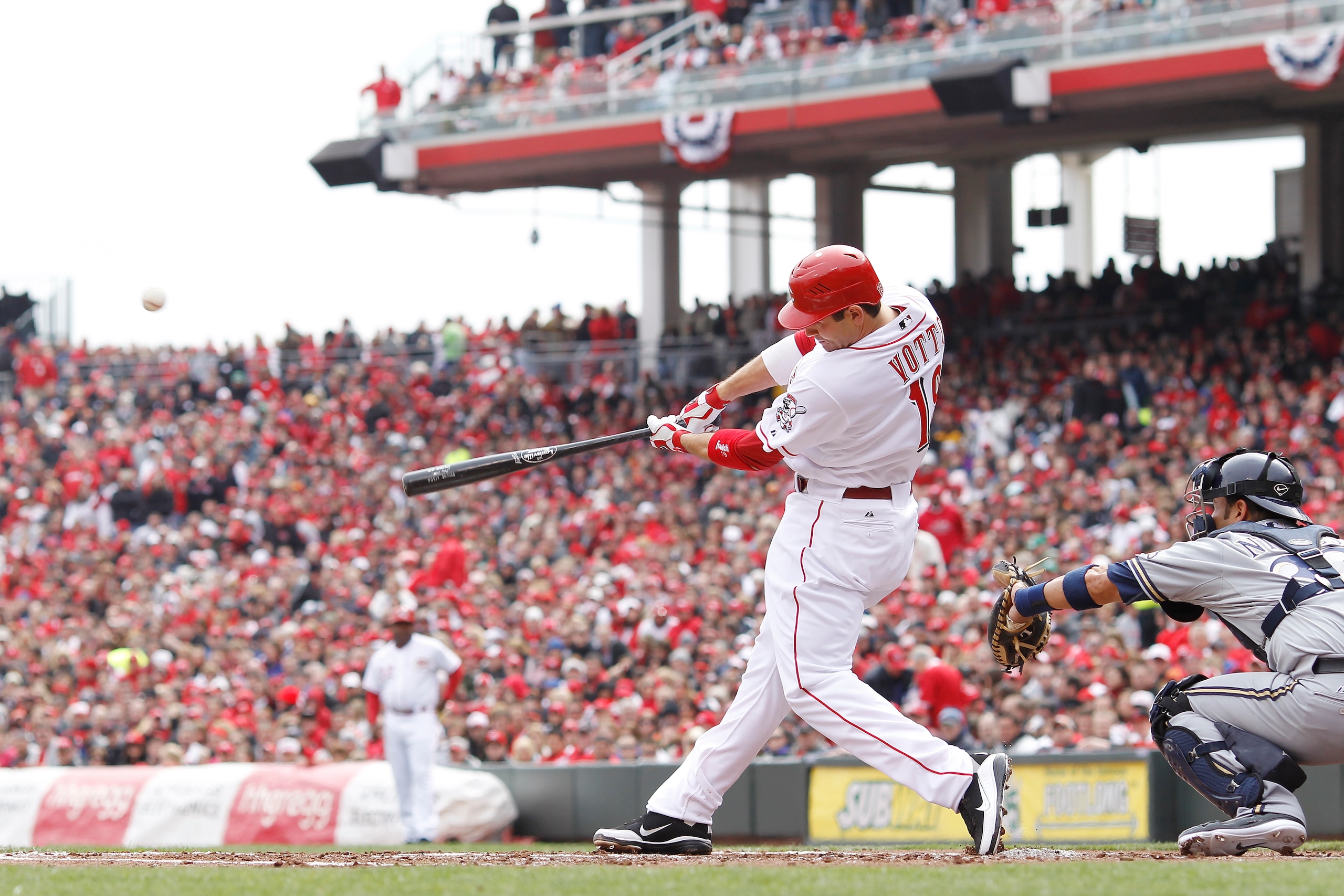 CINCINNATI, OH - MARCH 31: Joey Votto #19 of the Cincinnati Reds hits a sacrifice fly in the first inning against the Milwaukee Brewers in the opening day game at Great American Ballpark on March 31, 2011 in Cincinnati, Ohio. The Reds won 7-6. (Photo by J