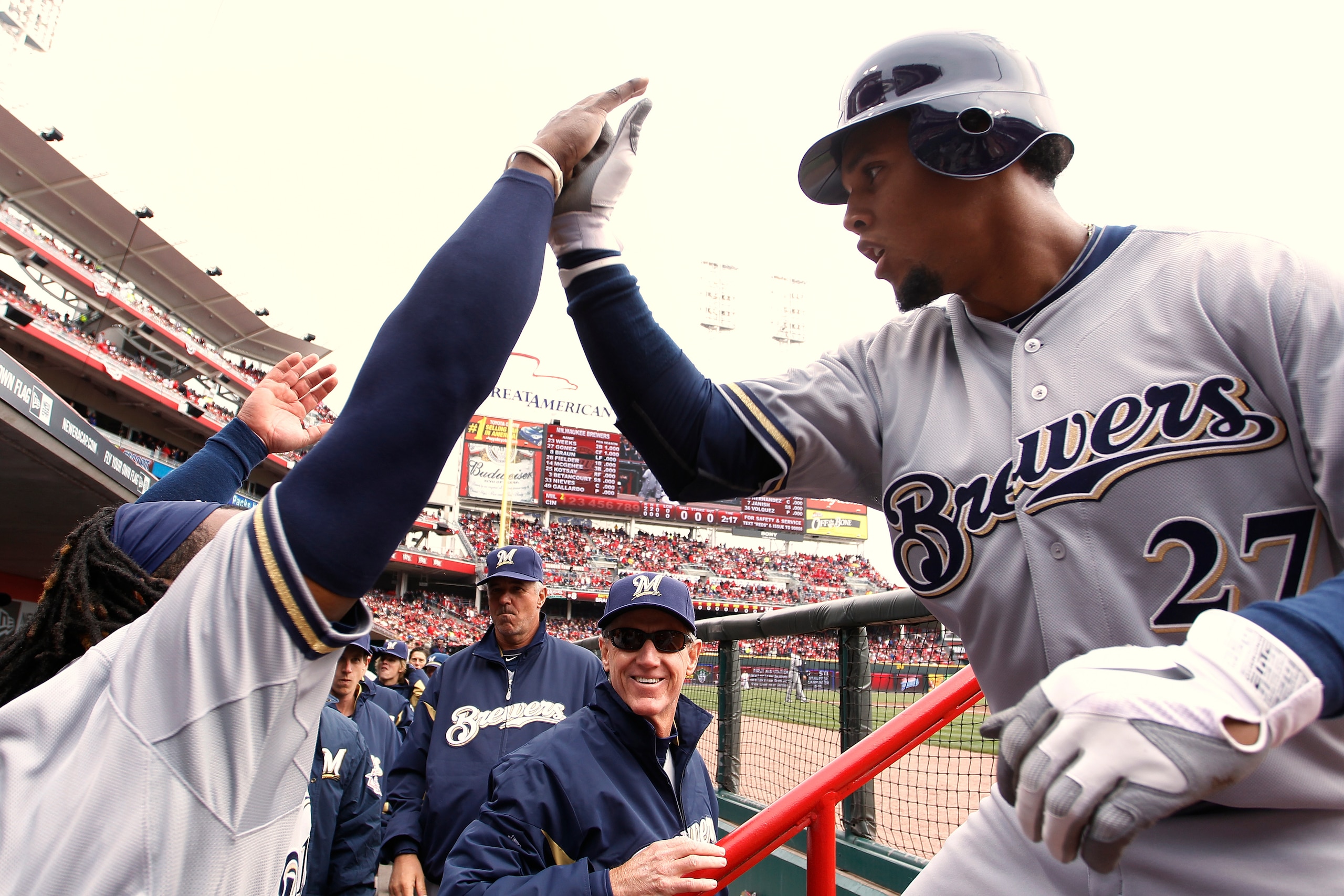 CINCINNATI, OH - MARCH 31: Carlos Gomez #27 of the Milwaukee Brewers celebrates with teammates after a first inning home run during the opening day game against the Cincinnati Reds at Great American Ballpark on March 31, 2011 in Cincinnati, Ohio. (Photo b
