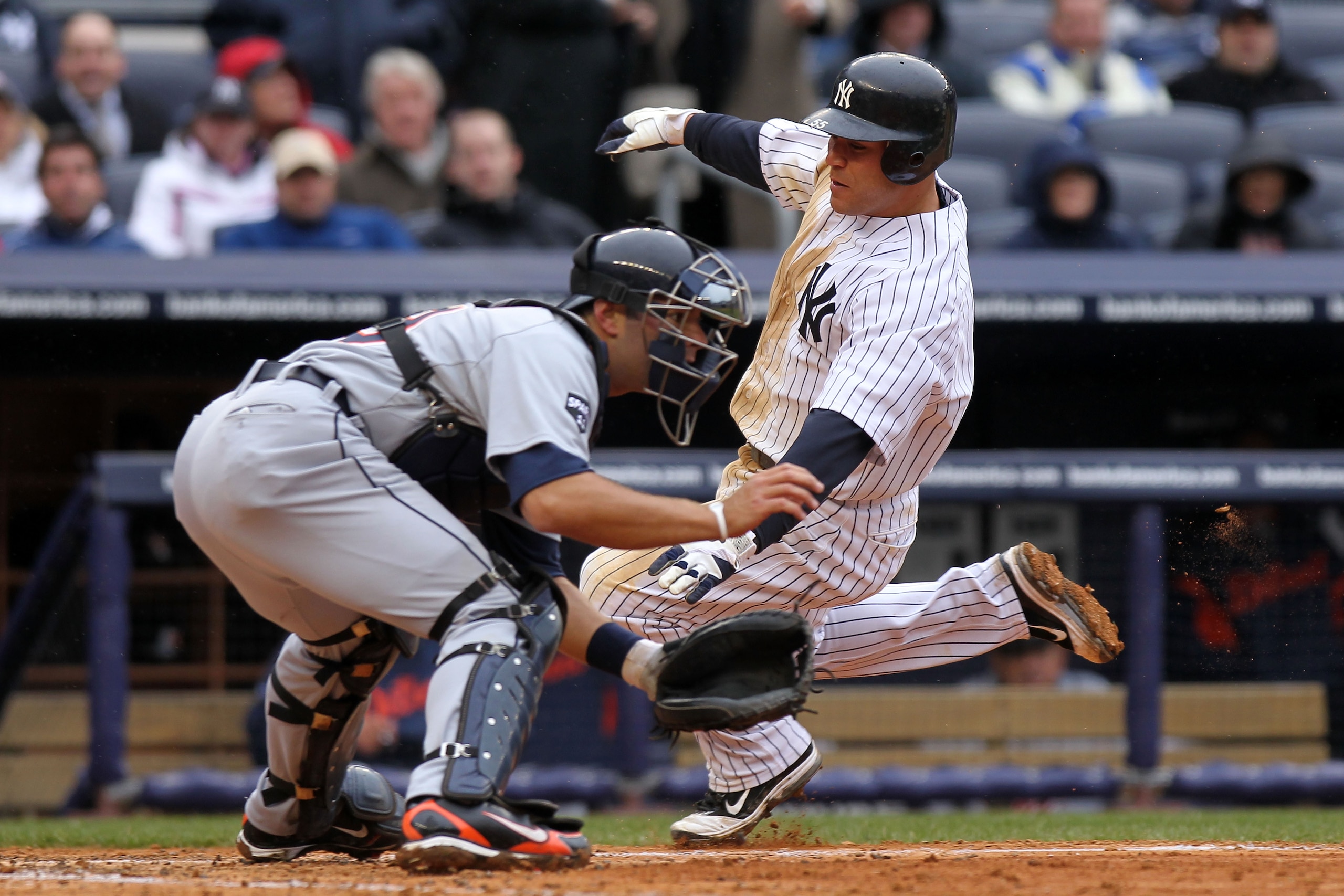 NEW YORK, NY - MARCH 31:  Russell Martin #55 of the New York Yankees slides into home against Alex Avila #13 of the Detroit Tigers in the seventh inning on Opening Day at Yankee Stadium on March 31, 2011 in the Bronx borough of New York City.  The Yankees