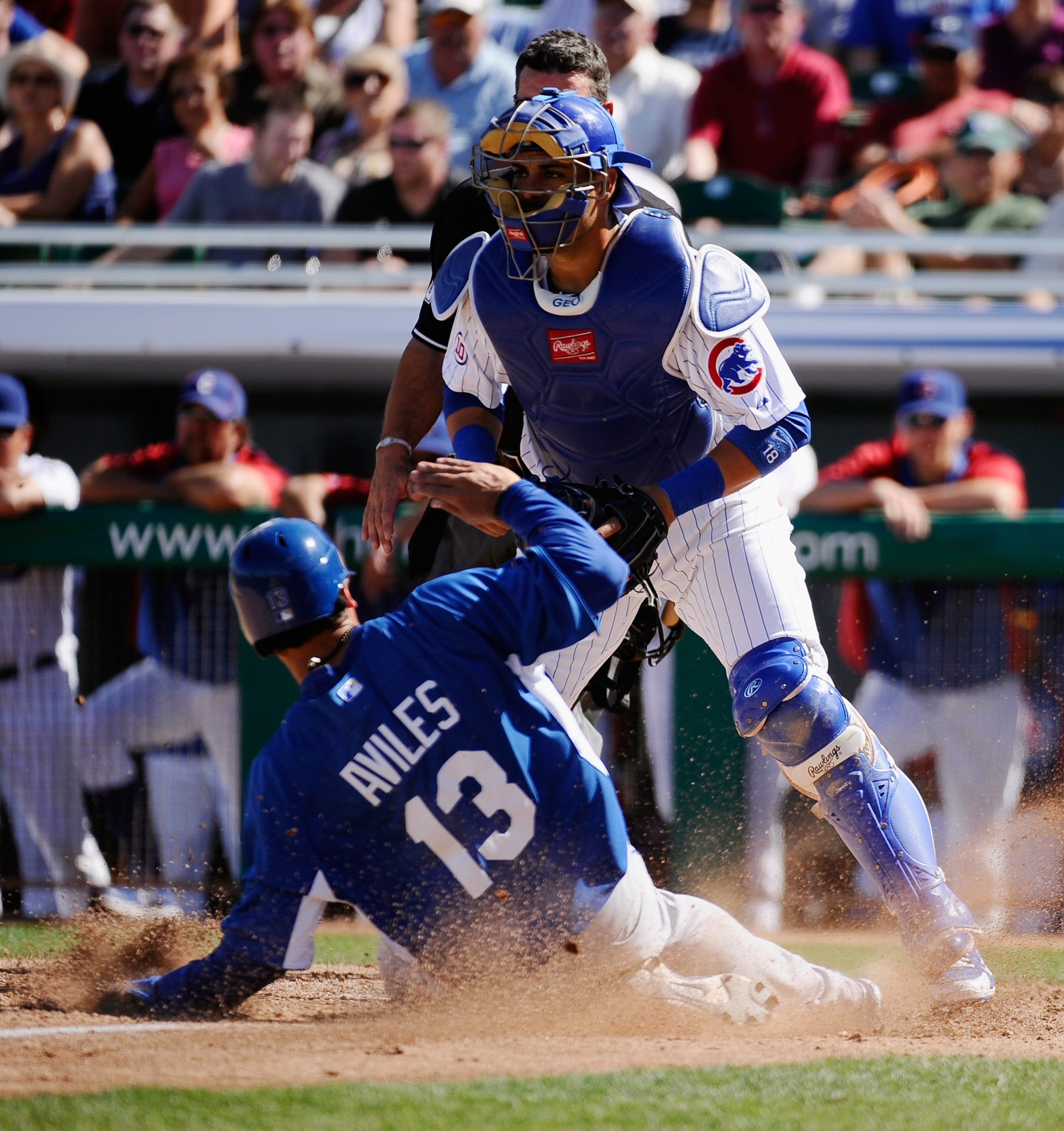 MESA, AZ - MARCH 09: Catcher Geovany Soto #18 of the Chicago Cubs looks for the throw to home plate as Mike Aviles #13 of the Kansas City Royals scores a run in the fourth inning of the spring training baseball game at HoHoKam Stadium on March 9, 2011 in