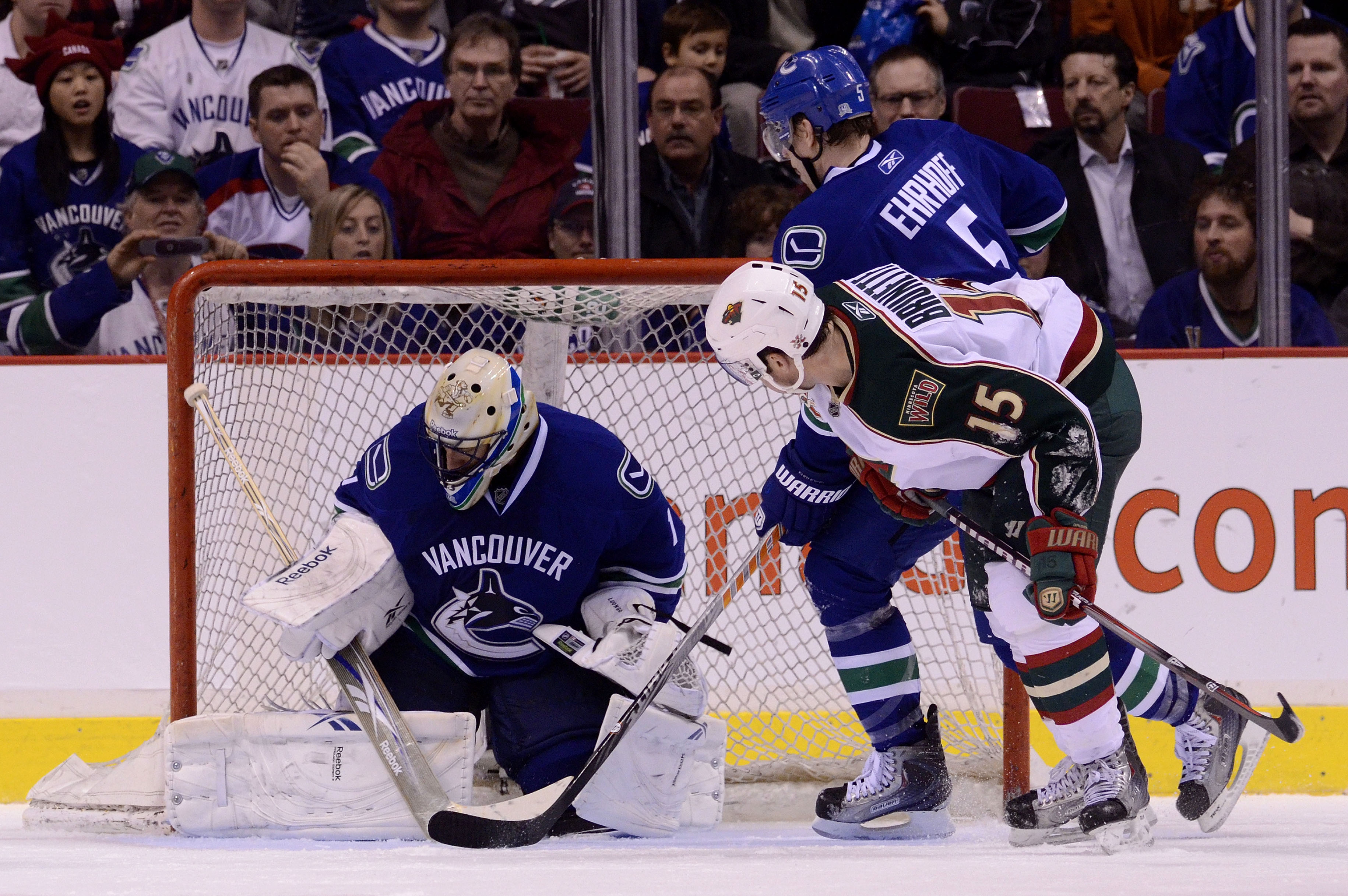 VANCOUVER, CANADA - MARCH 14: Andrew Brunette #15 of the Minnesota Wild and Christian Ehrhoff #5 of the Vancouver Canucks look on as goalie Roberto Luongo #1of the Vancouver Canucks makes a save and covers up the puck during the second period in NHL actio