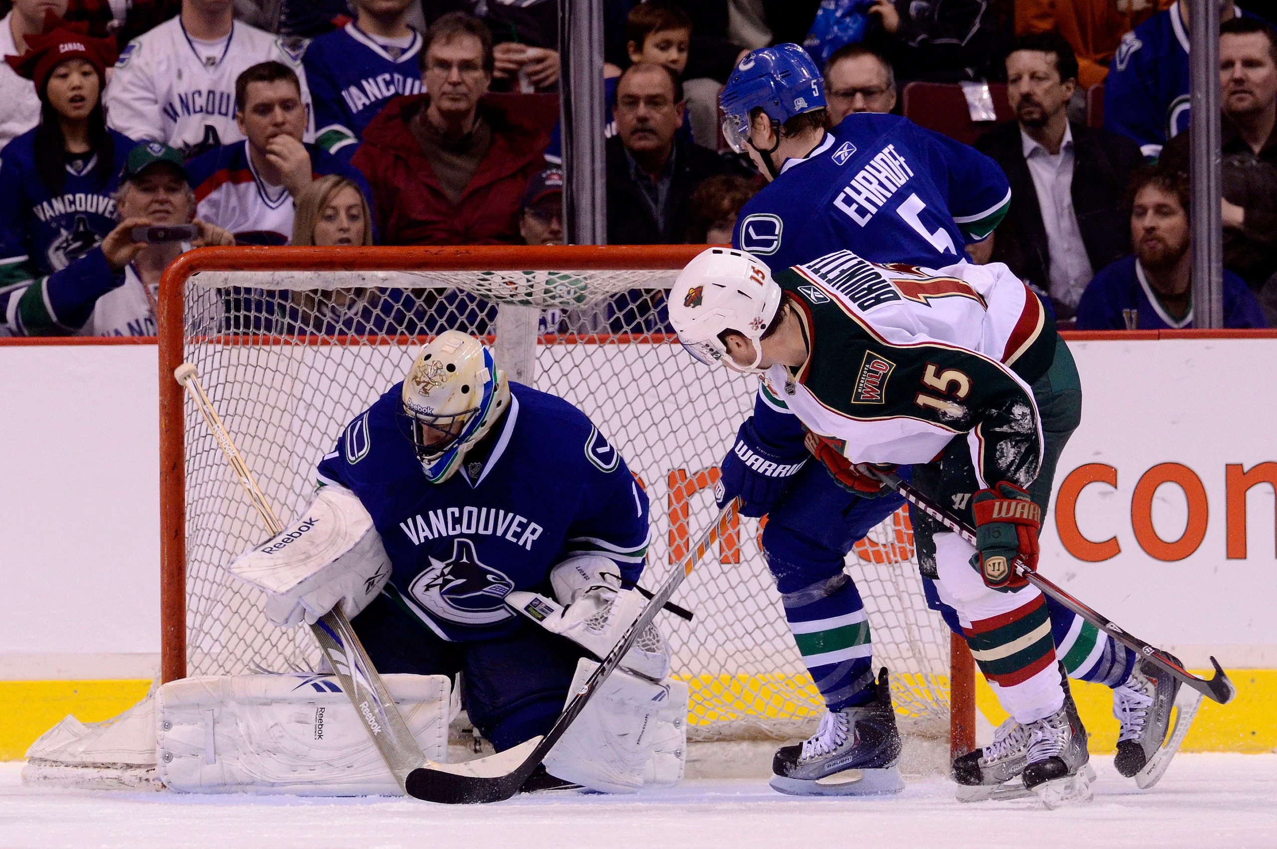 VANCOUVER, CANADA - MARCH 14: Andrew Brunette #15 of the Minnesota Wild and Christian Ehrhoff #5 of the Vancouver Canucks look on as goalie Roberto Luongo #1of the Vancouver Canucks makes a save and covers up the puck during the second period in NHL actio