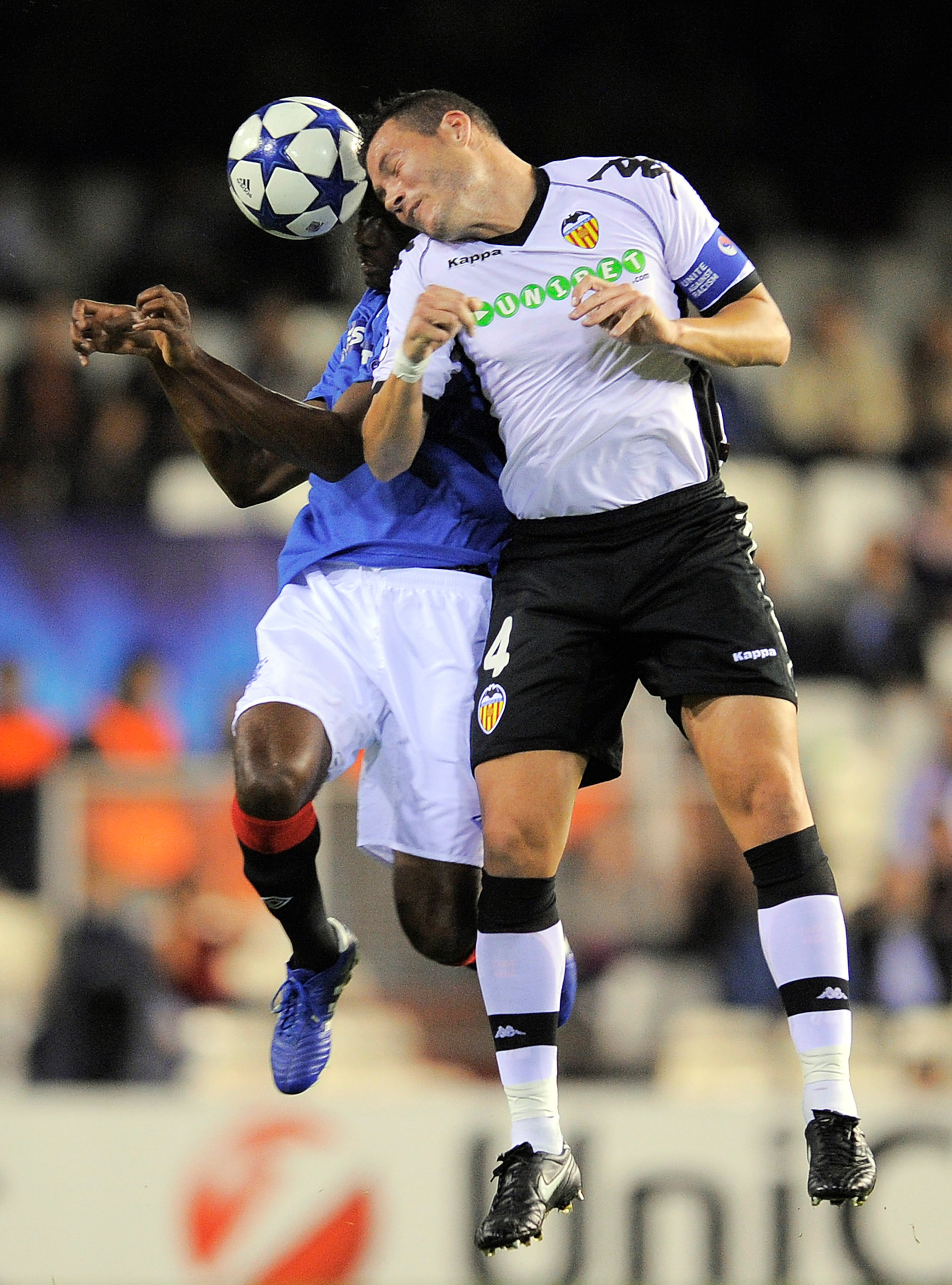 VALENCIA, SPAIN - NOVEMBER 02:  Maurice Edu of Glasgow Rangers (L) and David Navarro of Valencia CF duels for a high ball during their UEFA Champions League group C match between Valencia CF and Glasgow Rangers at the Mestalla Stadium on November 2, 2010