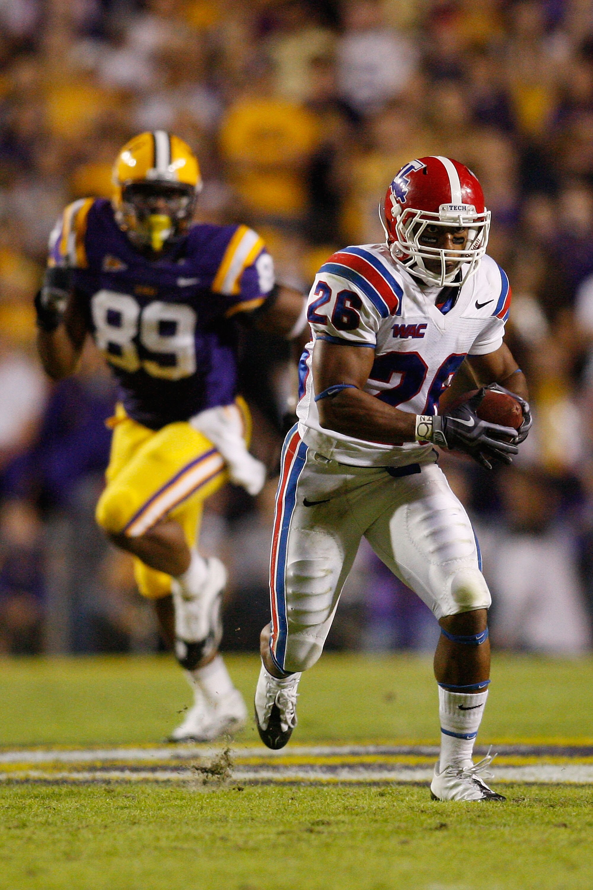 BATON ROUGE, LA - NOVEMBER 14:  Myke Compton #26 of the Louisiana Tech Bulldogs runs past Lavar Edwards #89 of the LSU Tigers at Tiger Stadium on November 14, 2009 in Baton Rouge, Louisiana.  (Photo by Chris Graythen/Getty Images)